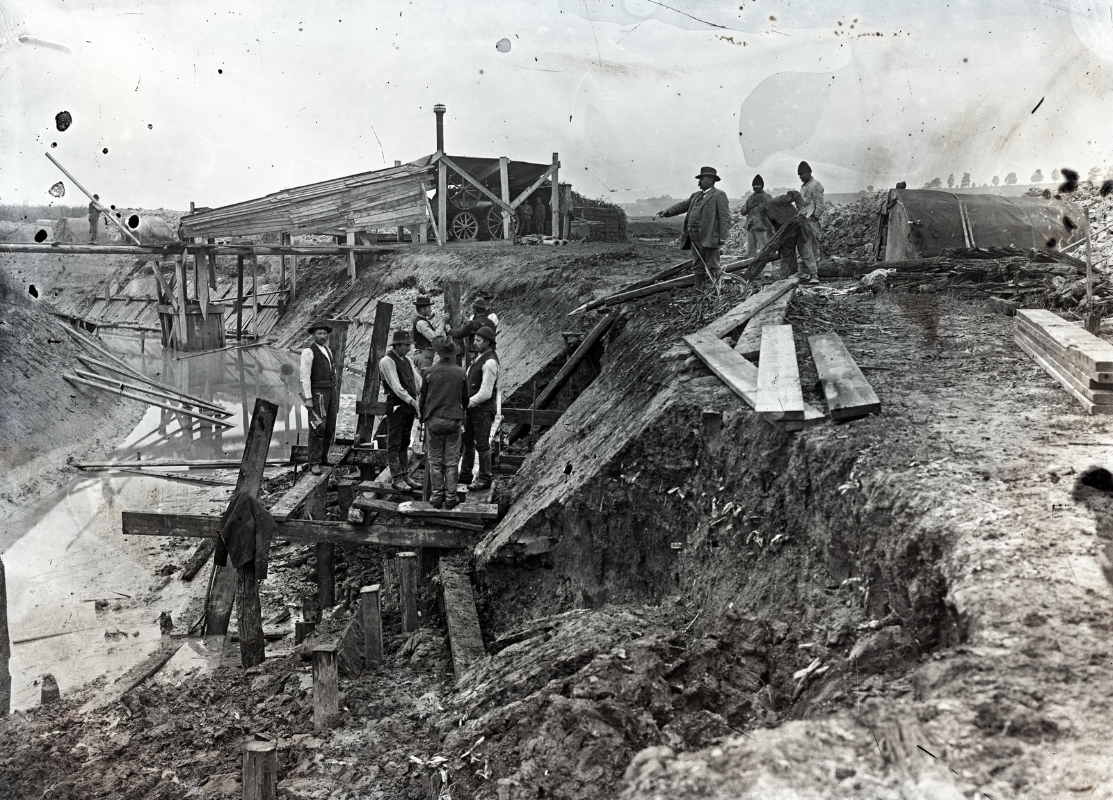 Hungary, »Kézi verőkossal cölöpverés és gőzgép vízszivattyúzása a Sió szabályozásánál, 1892-1893.« Leltári jelzet: MMKM TEMGY 2019.1.1. 0837, 1900, Magyar Műszaki és Közlekedési Múzeum / BAHART Archívum, damaged photo, board, point a finger, axe, traction engine, , Fortepan #183376