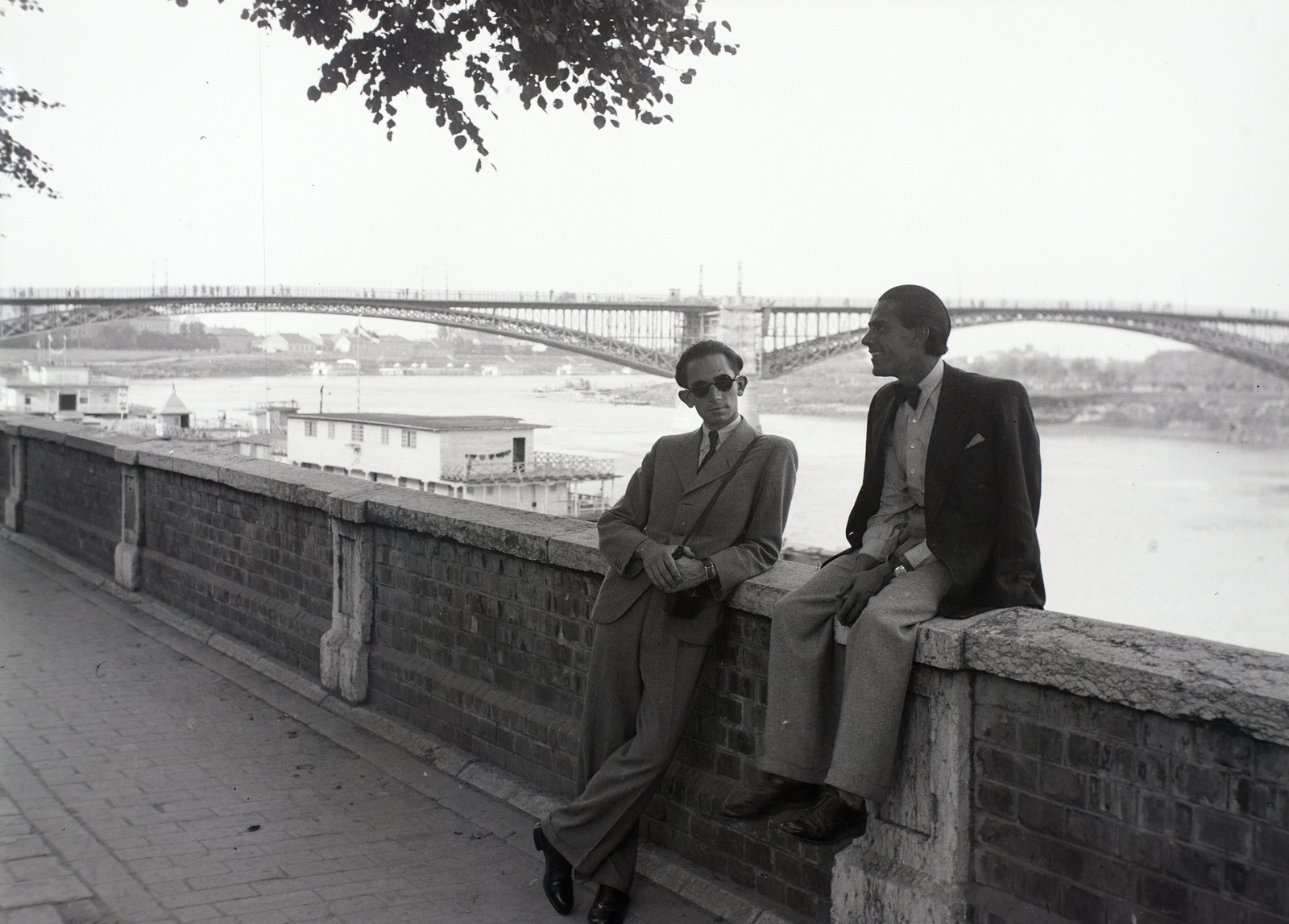 Hungary, Szeged, Tisza-part, háttérben a közúti híd., 1941, Ferencz Zoltán Zénó, bridge, men, sitting on a wall, Fortepan #184053