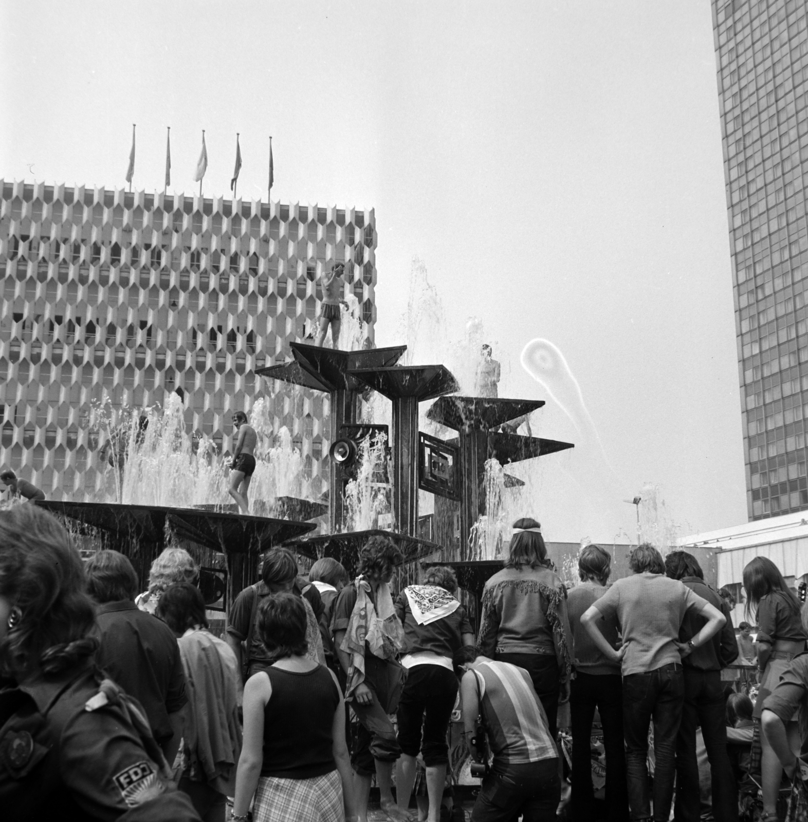 Németország, Berlin, Kelet-Berlin, Alexanderplatz. Középen a Népek Barátsága szökőkút (Brunnen der Völkerfreundschaft), balra a Centrum Áruház, jobbra a Hotel Stadt Berlin. A felvétel a X. VIT (Világifjúsági Találkozó) idején készült., 1973, Fortepan/Album036, NDK, Kelet-Berlin, Fortepan #184400