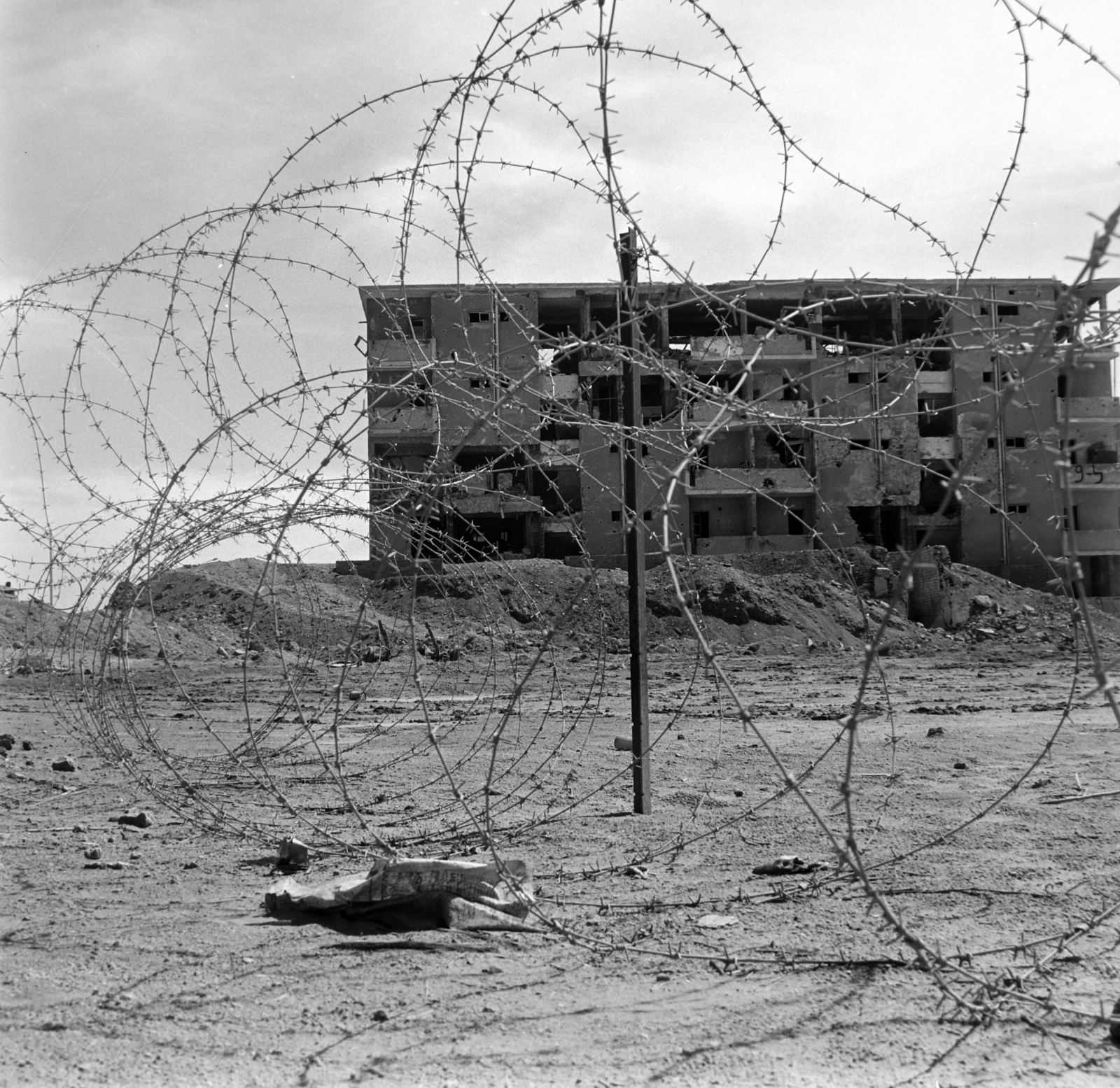 Egypt, El Muthallath telep a Július 23-a út mellett. A drótkerítés mögött az 1973-as Yom Kippur háborúban megrongálódott épület látható., 1974, Fortepan/Album036, barb wire, damaged building, Fortepan #184455