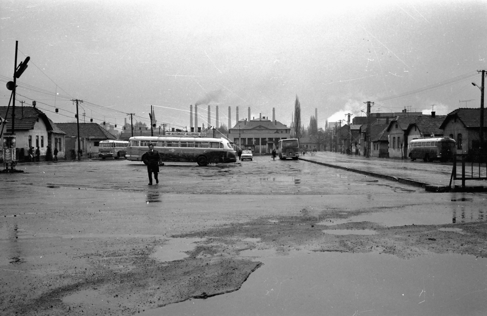 Hungary, Ózd, Petőfi tér, autóbusz-állomás, háttérben takarva aTanácsháza (később Városi Könyvtár), balra az oszlop takarásában a Szent Kereszt Felmagasztalása templom, jobbra a Tanácsháza sarkánál a református templom., 1975, Kende János, bus, Ikarus-brand, Fortepan #185219