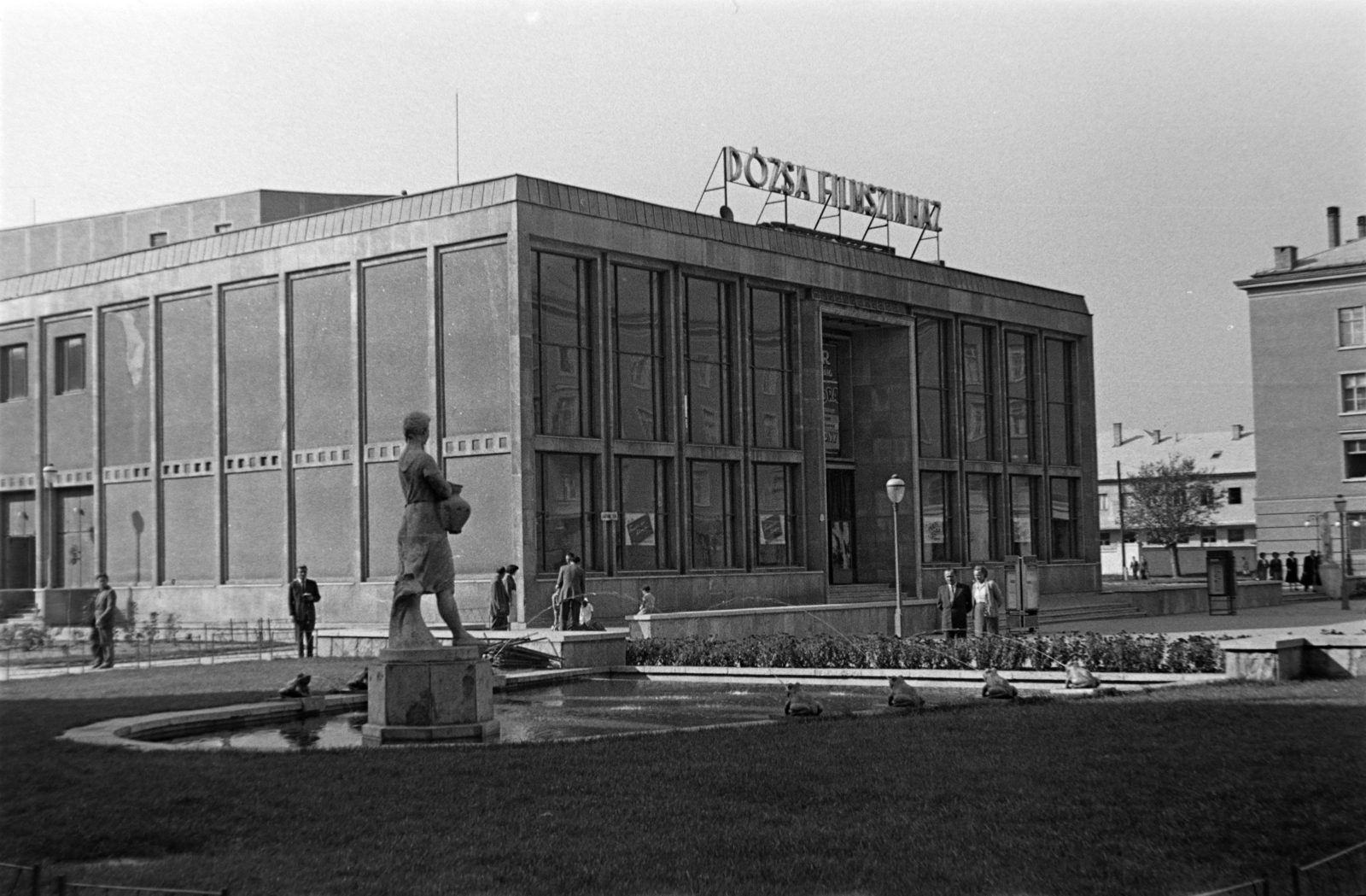 Hungary, Dunaújváros, (Sztálinváros), Dózsa György (Ságvári) tér, a Korsós lány szobra Wagner Nándor alkotása (1955)., 1955, Tóth Tibor, sculpture, modern architecture, flat roof, movie theater, fountain, female figure, Fortepan #185577