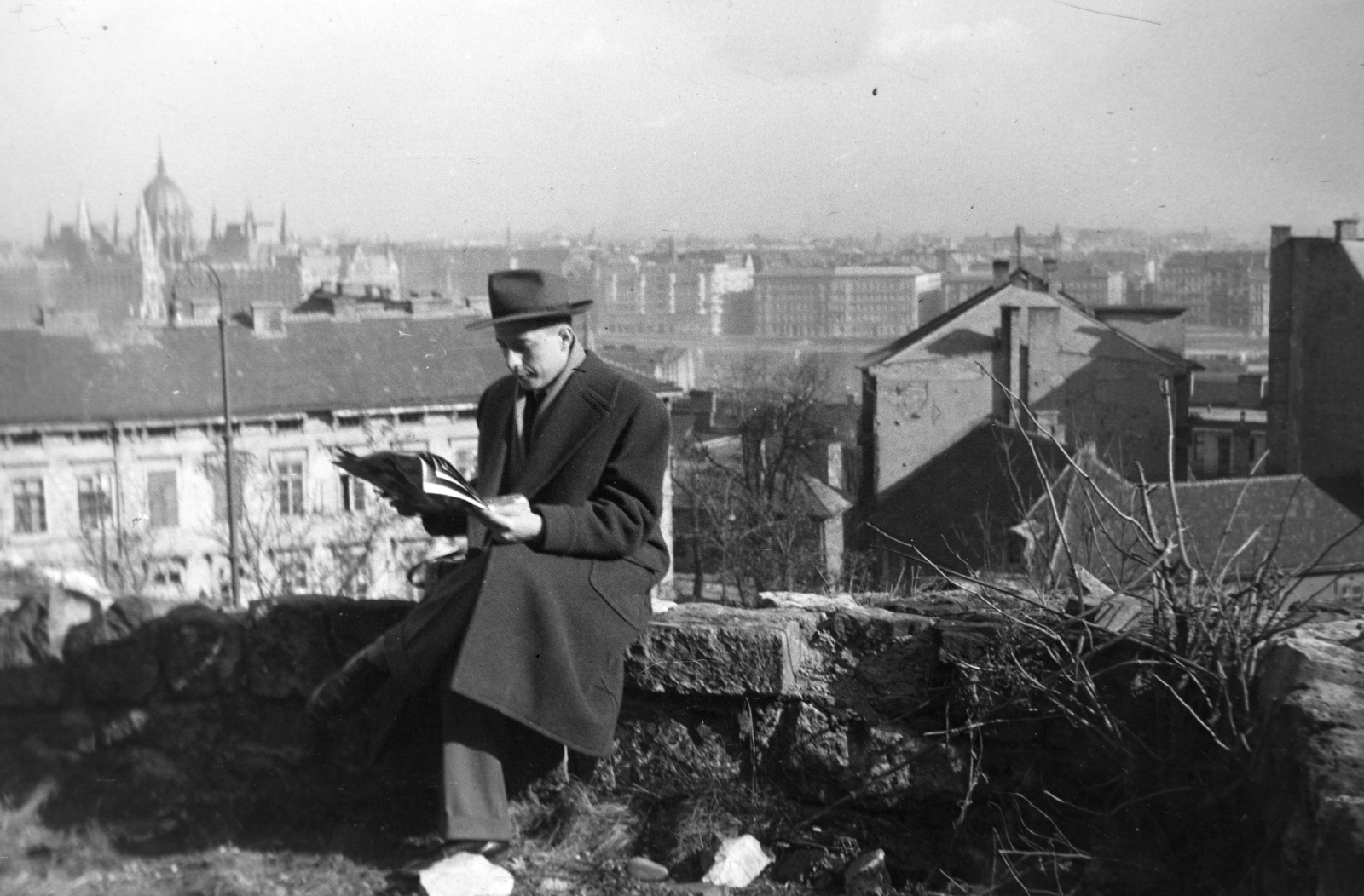 Hungary, Budapest I., kilátás a Hunyadi János út melletti kőfalról a Donáti utca torkolata felé, háttérben balra a Parlament., 1957, Tóth Tibor, Budapest, newspaper, reading, sitting on a wall, Fortepan #185658