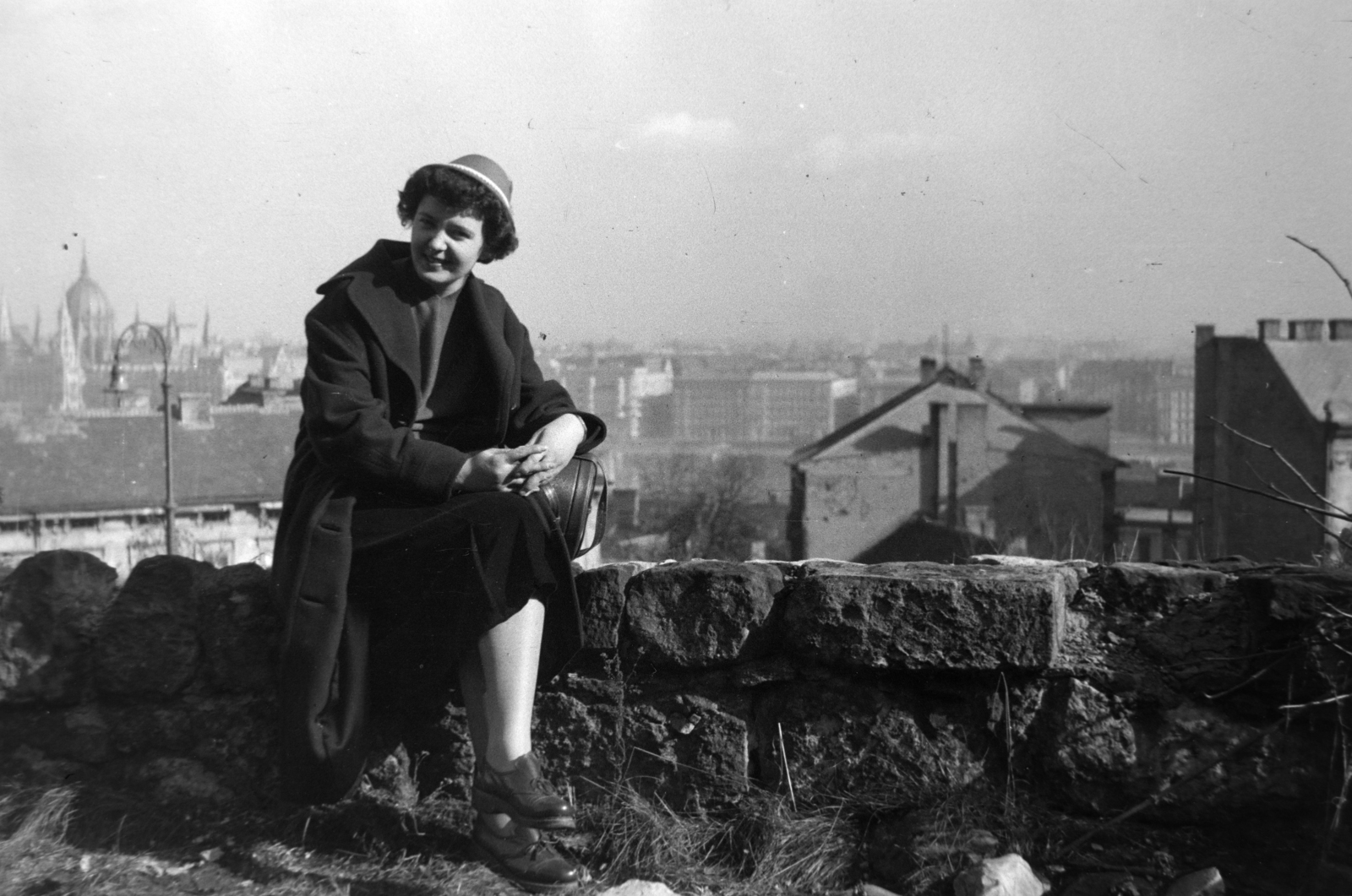 Hungary, Budapest I., kilátás a Hunyadi János út melletti kőfalról a Donáti utca torkolata felé, háttérben balra a Parlament., 1957, Tóth Tibor, Budapest, lady, sitting on a wall, Fortepan #185659