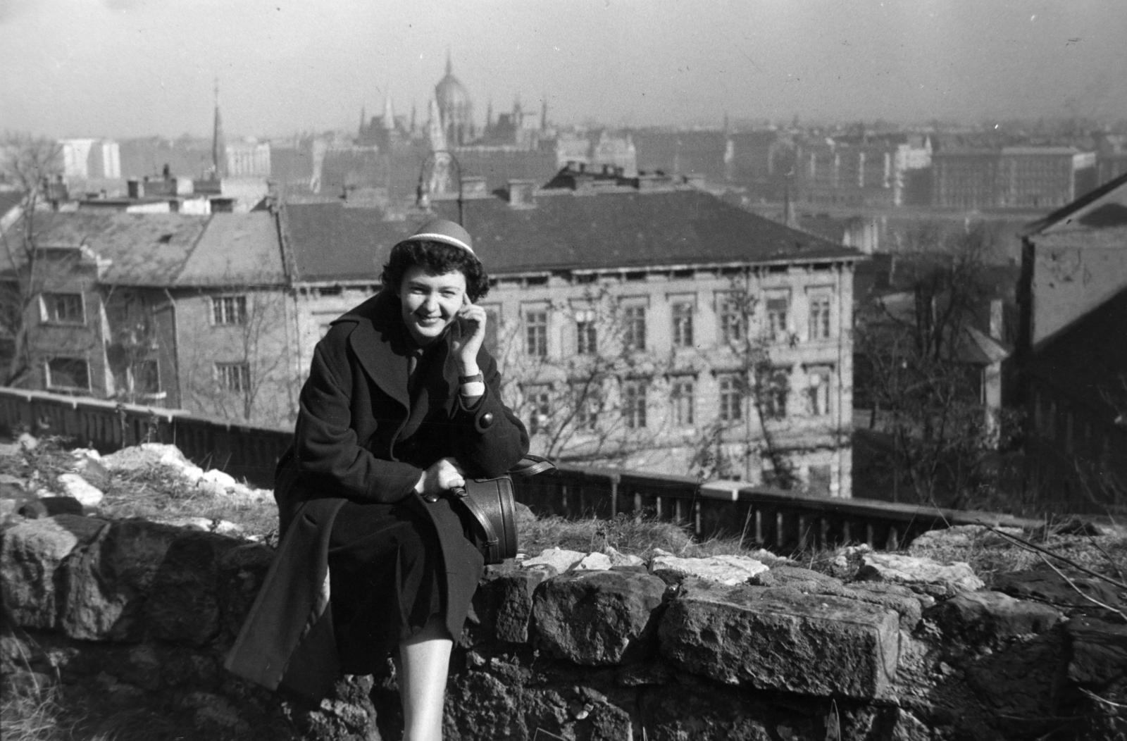 Hungary, Budapest I., kilátás a Hunyadi János út melletti kőfalról, háttérben a Parlament., 1957, Tóth Tibor, Budapest, lady, prop up on elbows, sitting on a wall, Fortepan #185660