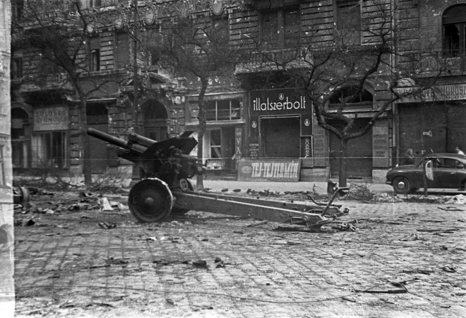 Hungary, Budapest IX., Ferenc körút, középen a 27. számú ház., 1956, Gulyás Zsuzsa, Budapest, M30 howitzer, street view, revolution, sign-board, dairy, perfume store, Fortepan #186578