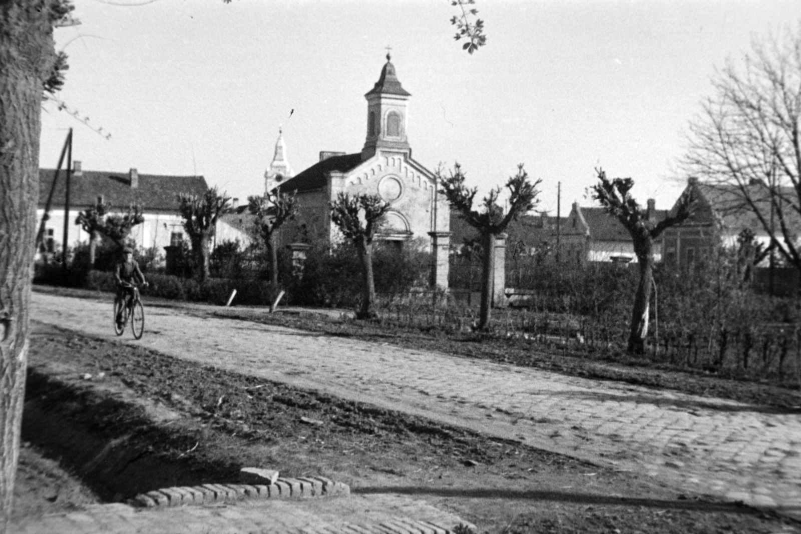 Hungary, Makó, Szent János tér, szemben a Szent János-kápolna, háttérben a református templom tornya., 1945, Fortepan/Album038, man, spring, bicycle, road, wood, Fortepan #186900
