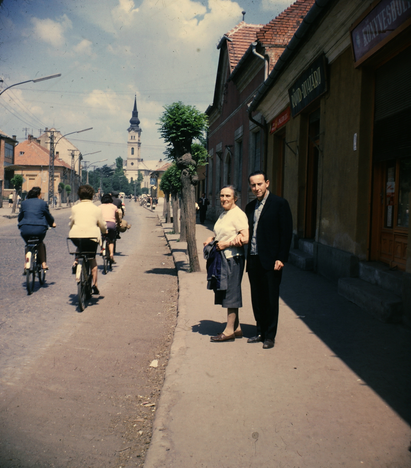 Magyarország, Mezőkövesd, Mátyás király út (Tanácsköztársaság utca), szemben a Szent László-templom., 1966, Markus Marianna, Magyar Gábor, színes, utcakép, templom, emberpár, kerékpár, Fortepan #187032