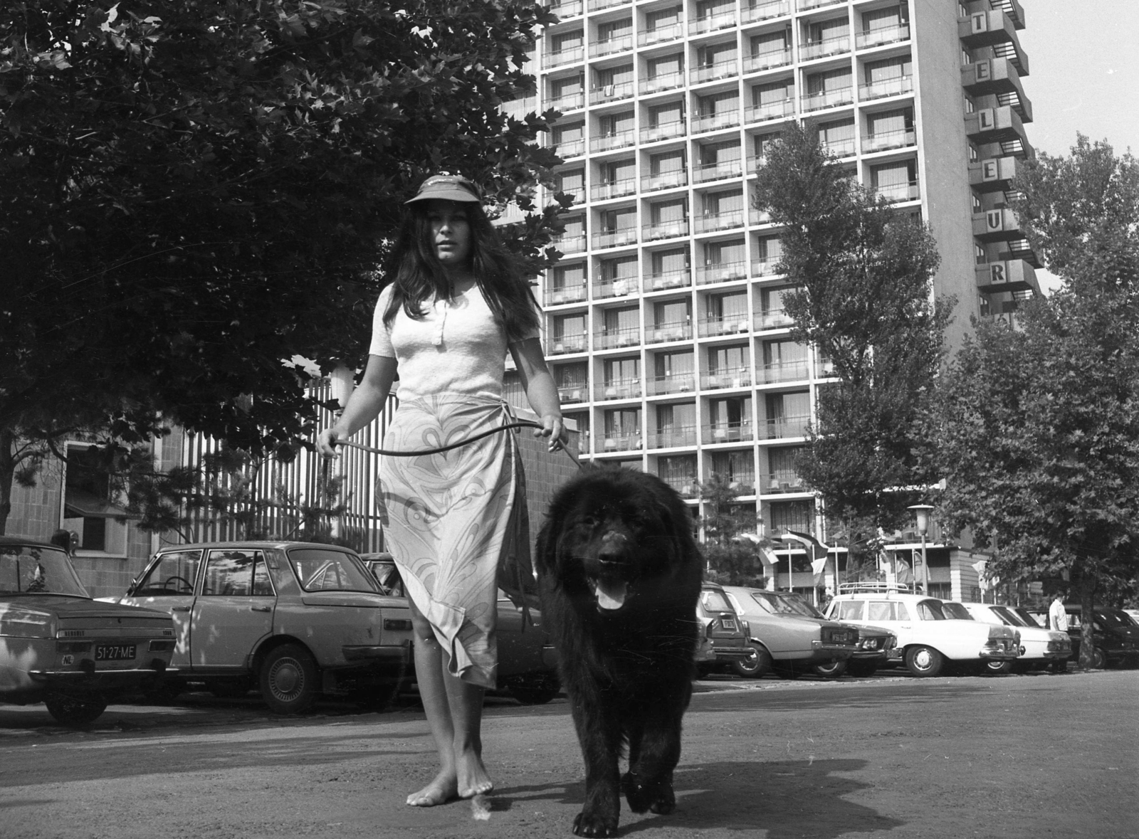 Hungary,Lake Balaton, Siófok, Hotel Európa., 1971, Urbán Tamás, fashion, dog, hotel, Mercedes-brand, Renault-brand, Wartburg-brand, BMW-brand, automobile, barefoot, number plate, walking the dog, country code sign, Fortepan #18771