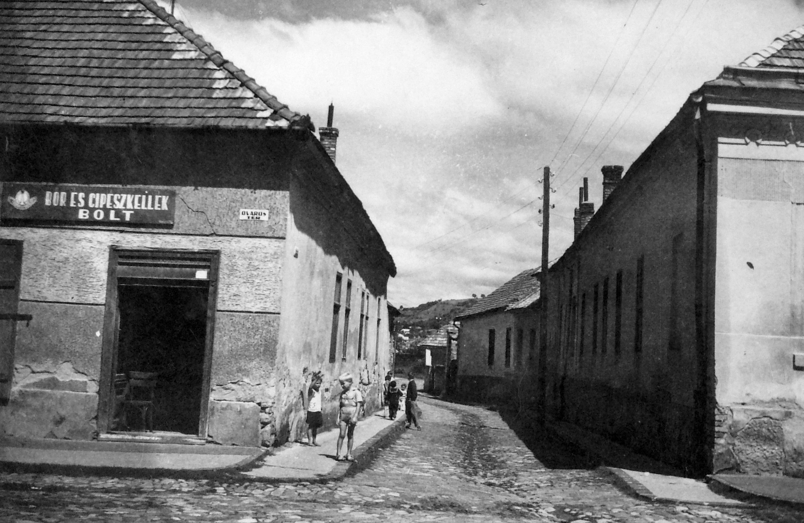 Hungary, Balassagyarmat, Vár utca, az Óváros térről nézve, szemben a háttérben a tótgyarmati dombok., 1955, Torjay Attila, street name sign, shoemaker, village, Fortepan #18883