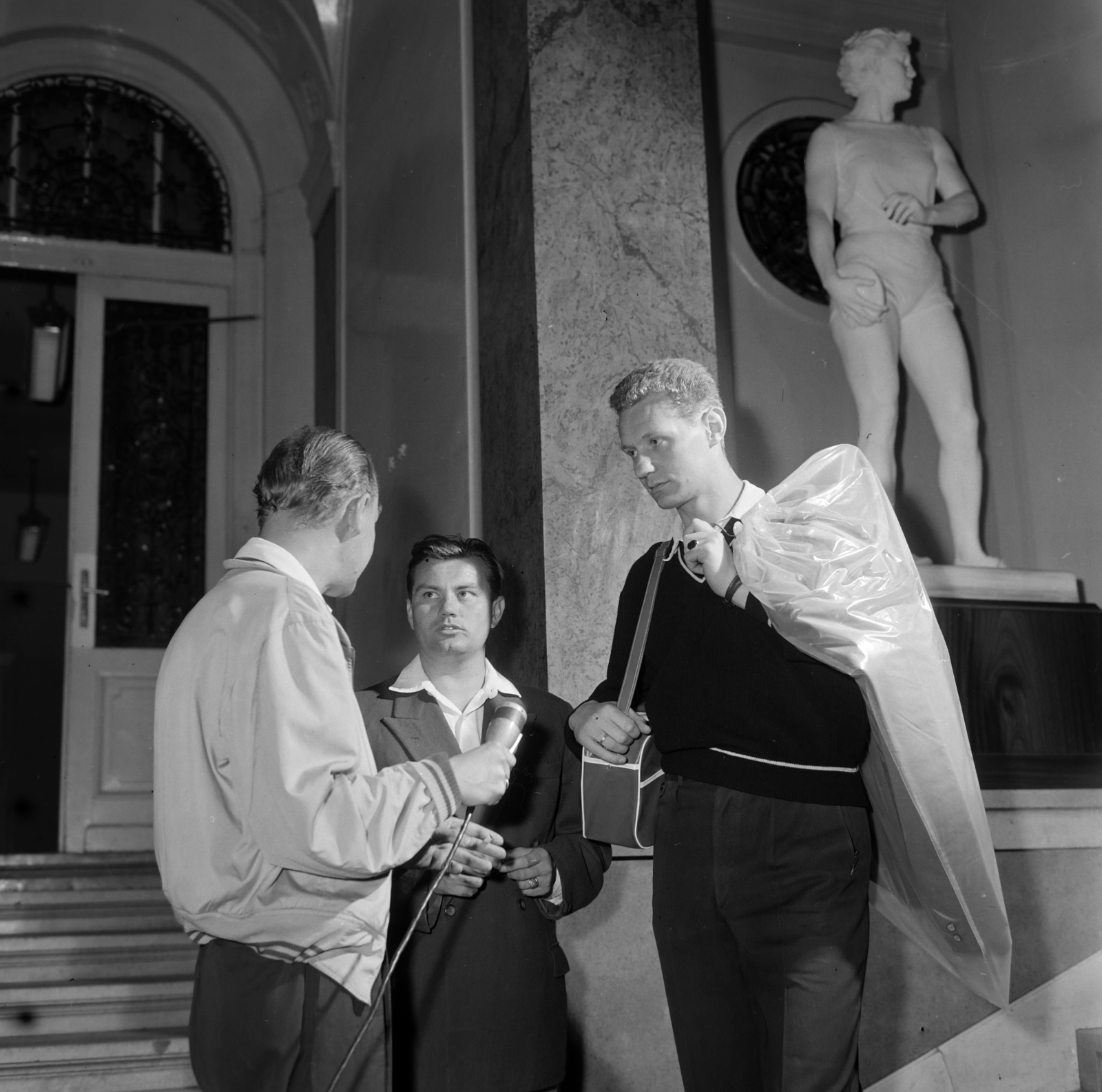 Hungary, Budapest V., Váci utca 62-64., a pesti Új Városháza előcsarnoka. Jobbra a háttérben Ambrózy Sándor szobrászművész Diszkoszvetőnő című szobra. Középen Páder János kosárlabda edző (később a MOB alelnöke), jobbra Bánhegyi László kosárlabdázó, később kungfu nagymester., 1959, Szalay Zoltán, Budapest, microphone, Fortepan #190556