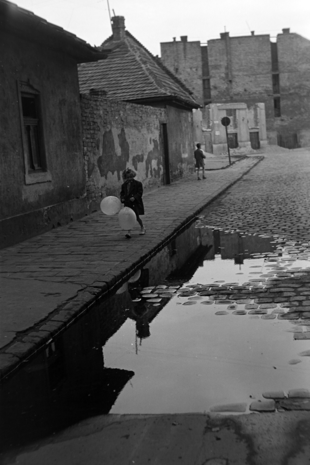 Hungary, Budapest VIII., a mára megszűnt Beniczky Lajos utca a Bókay János utca felé nézve., 1954, Kriss Géza, Budapest, girl, reflection, firewall, pavement, puddle, baloon, Fortepan #191795