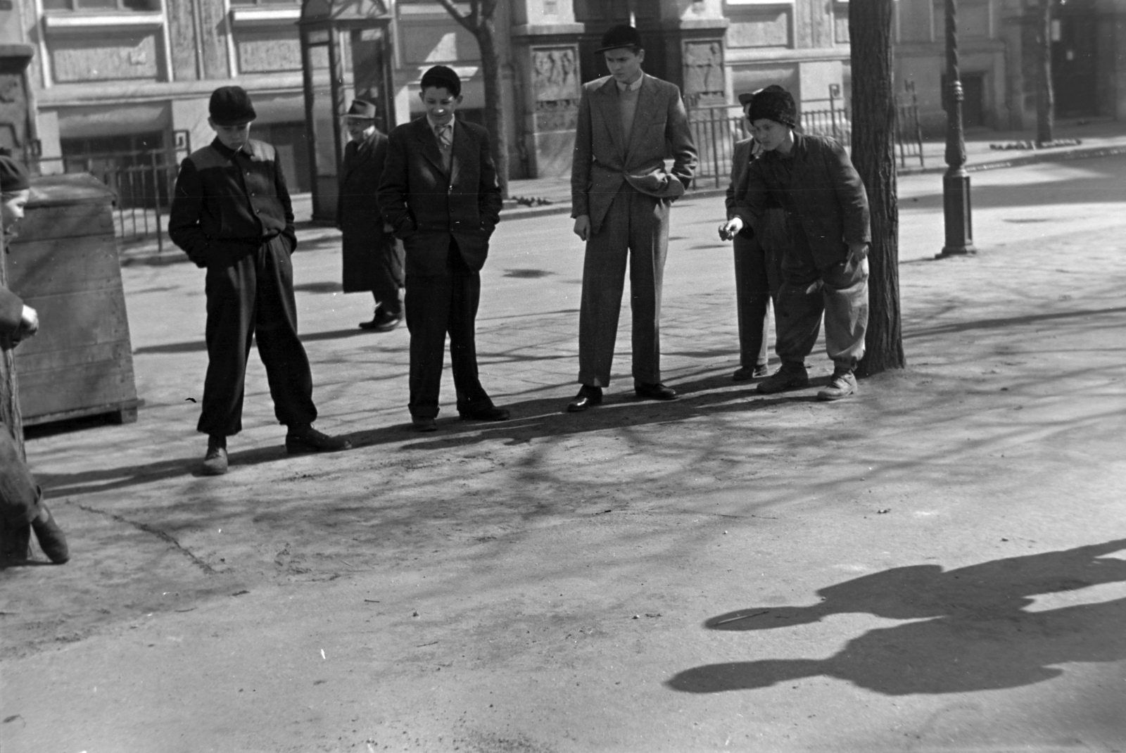 Magyarország, Budapest VIII., Horváth Mihály tér, snúrozó fiúk. Háttérben a Horváth Mihály téri Gyakorló Általános Iskola (később Budapesti Fazekas Mihály Gyakorló Általános Iskola és Gimnázium)., 1955, Kriss Géza, Budapest, játék, fiúk, fény-árnyék, Fortepan #191883