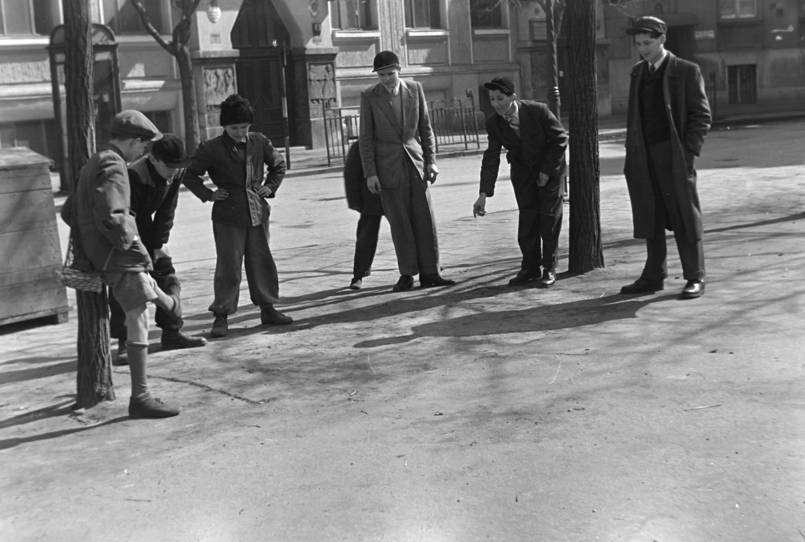 Hungary, Budapest VIII., Horváth Mihály tér, snúrozó fiúk. Háttérben a Horváth Mihály téri Gyakorló Általános Iskola (később Budapesti Fazekas Mihály Gyakorló Általános Iskola és Gimnázium)., 1955, Kriss Géza, Budapest, boys, akimbo, spreading, one leg standing, Fortepan #191889