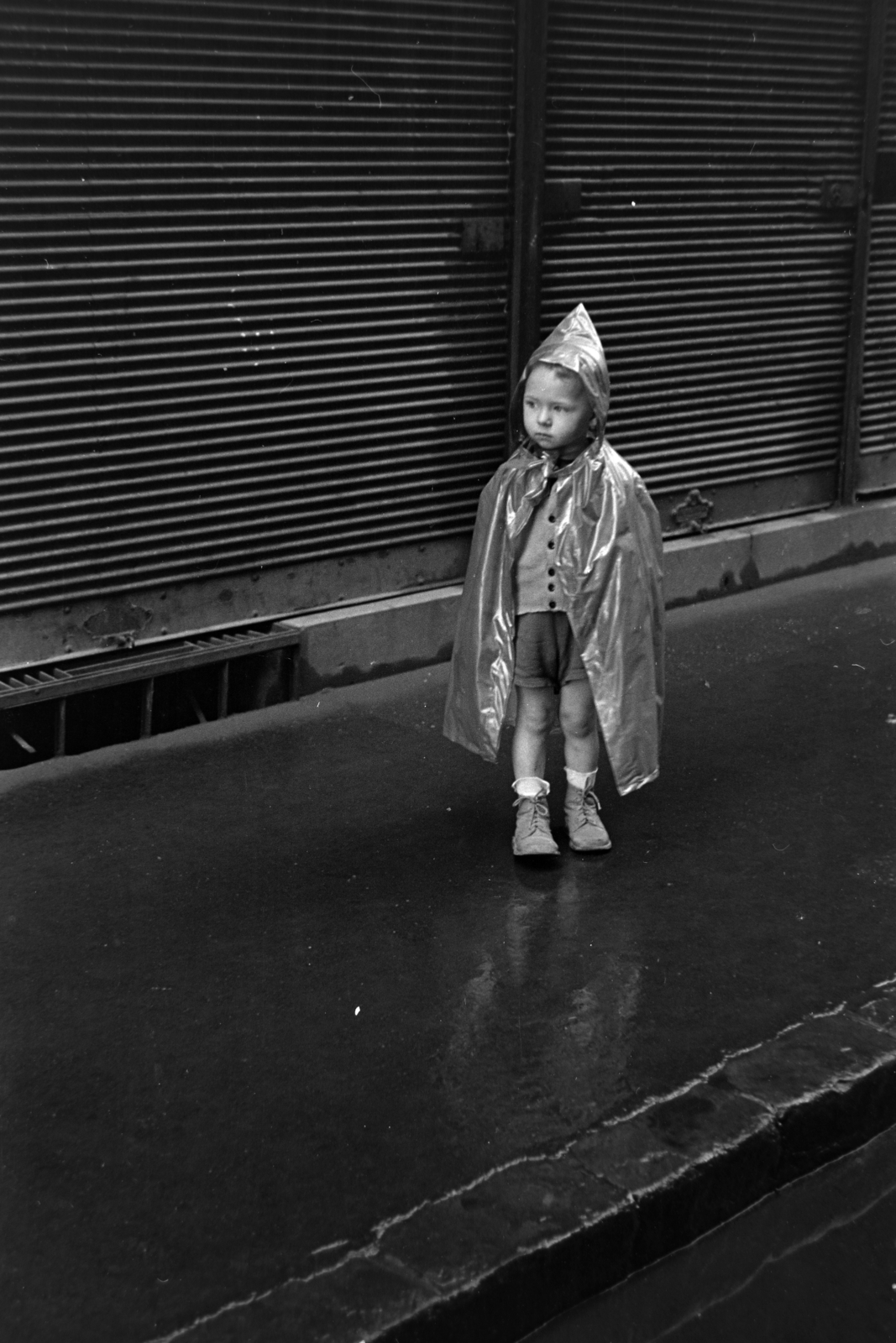 Hungary, Budapest VIII., a felvétel a Baross utca 87. számú sarokház oldalfrontja előtt készült., 1956, Kriss Géza, Budapest, kid, raincoat, pavement, shutter, Fortepan #191925