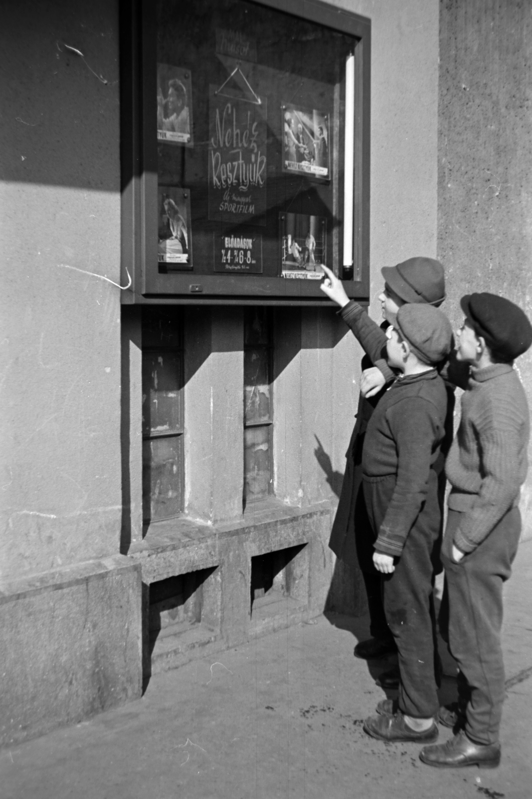 Hungary, Budapest VIII., a felvétel a mára megszűnt Beniczky Lajos utca 3-5. számú házban lévő Otthon mozi előtt készült, 1957, Kriss Géza, Budapest, boys, point a finger, movie schedule, Fortepan #191944