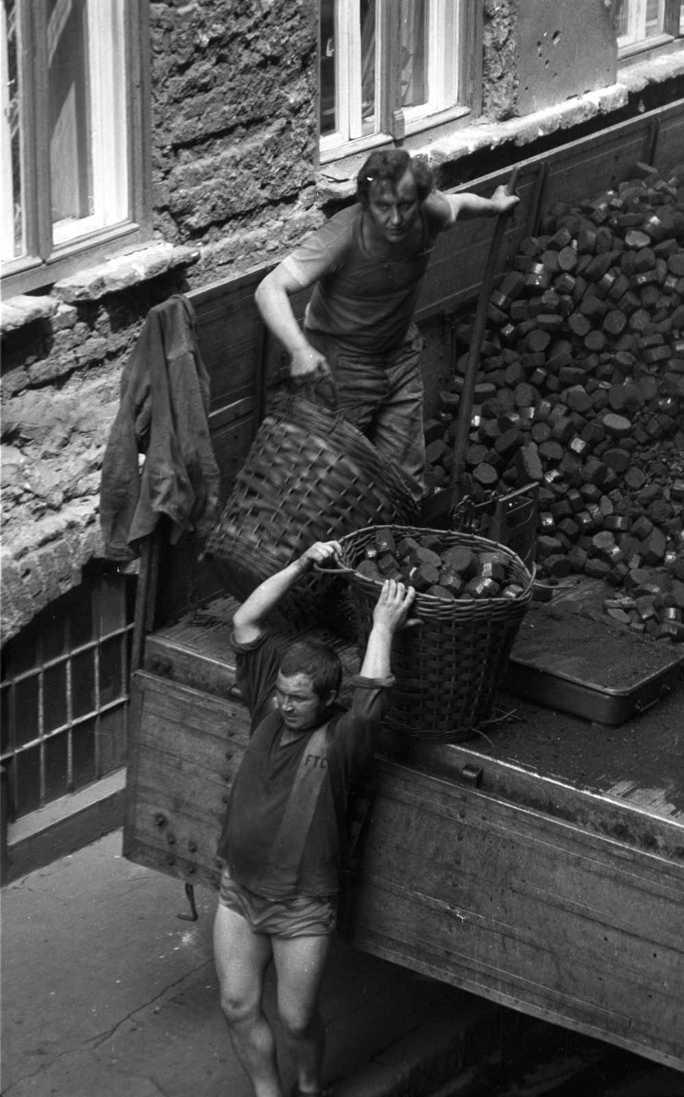 Hungary, Budapest VIII., Nagy Templom utca, tüzelőhordás a 5-ös számú ház kapujánál. A felvétel a Práter utca 34-ből készült., 1979, Kriss Géza, Budapest, coalman, coal basket, coal, Fortepan #192349