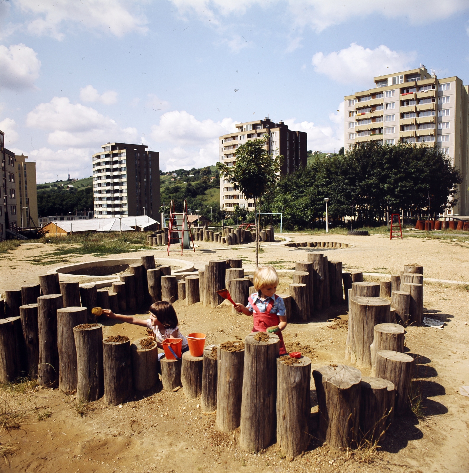 Hungary, Zalaegerszeg, játszótér a Pais Dezső utcában, háttérben a Landorhegyi út épületei., 1983, Gábor Viktor, playground, colorful, log castle, Fortepan #193578