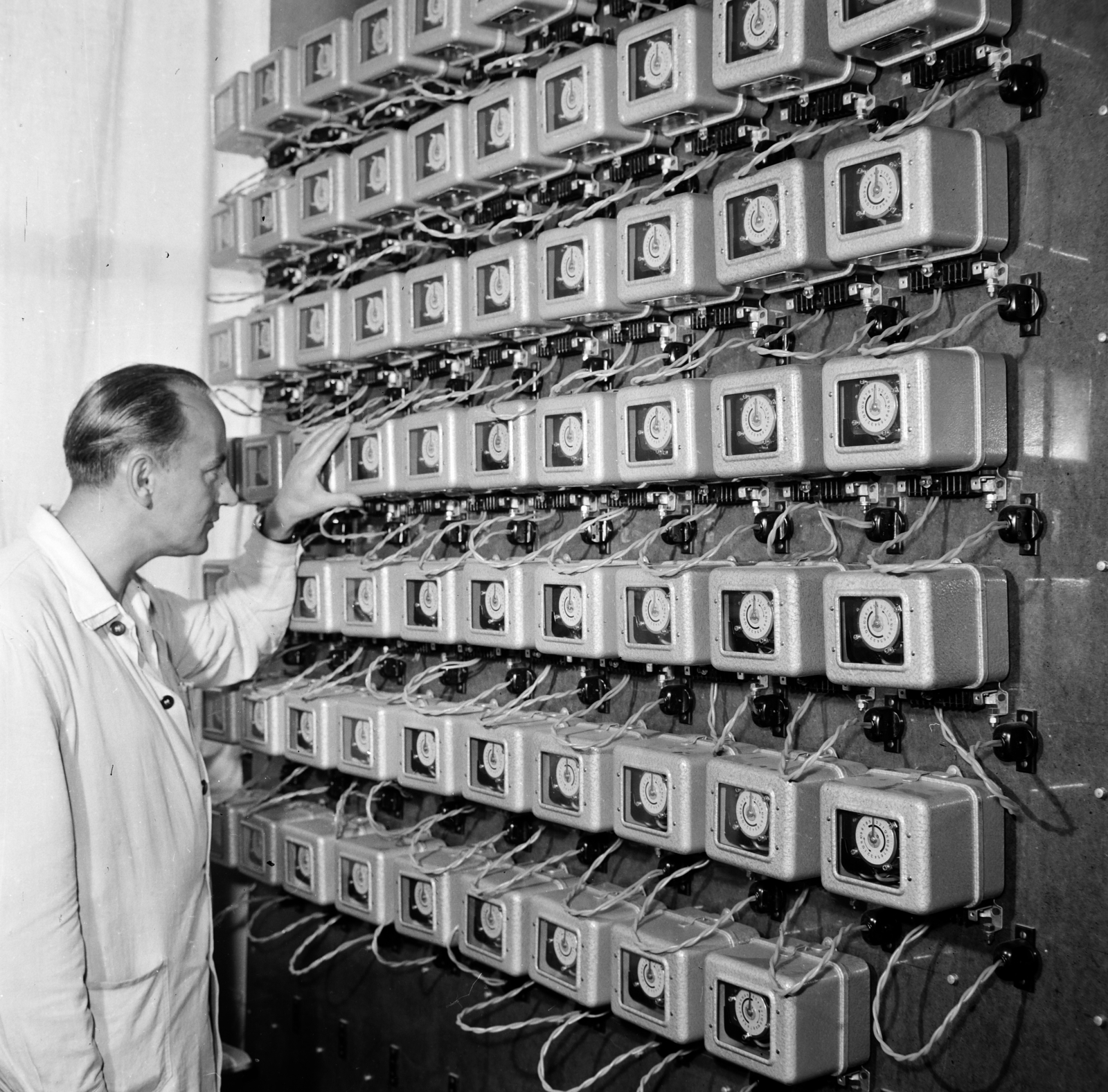 Hungary, Gödöllő, a Ganz Árammérő Gyár műszerésze ellenőrzi a gyár termékét, a VKM típusú villamosfelhúzású kapcsolóórákat., 1967, Gábor Viktor, Fortepan #194136