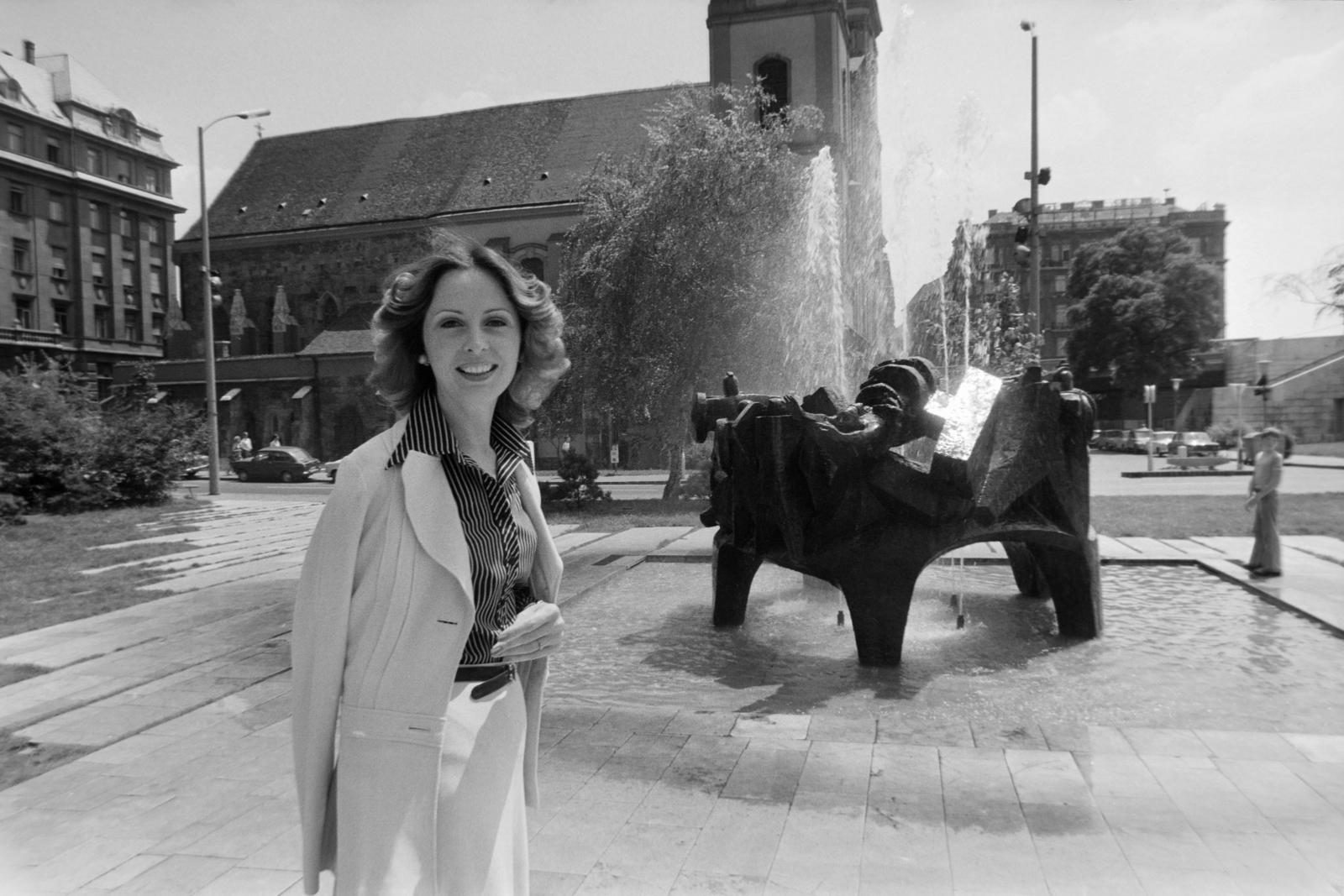 Hungary, Budapest V., Március 15. tér, Berkes Zsuzsa tévébemondó. Tar István szobrászművész alkotása (1971) Barbárok harca a rómaiakkal szökőkút / szoborcsoport, háttérben a Belvárosi templom., 1982, Gábor Viktor, church, Budapest, Fortepan #194419