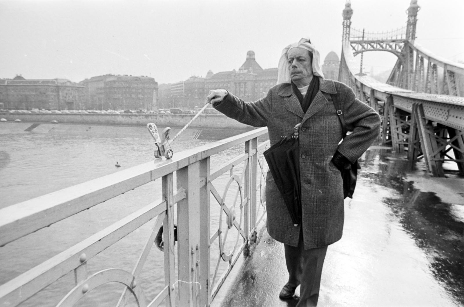 Hungary, Budapest XI., Szabadság híd, háttérben a Szent Gellért tér épületei. Harmath István fényképész mint a maga által, mindenek előtt magára vonatkoztatva alapított Világ Legnagyobb Marhája kitüntetés alapítója, pillangóját sétáltatja. A felvétel az évente megtartott Bedobás / felesleges tárgyak Dunába dobása alkalmával készült., 1979, Gábor Viktor, Budapest, Budapest University of Technology, Fortepan #194452