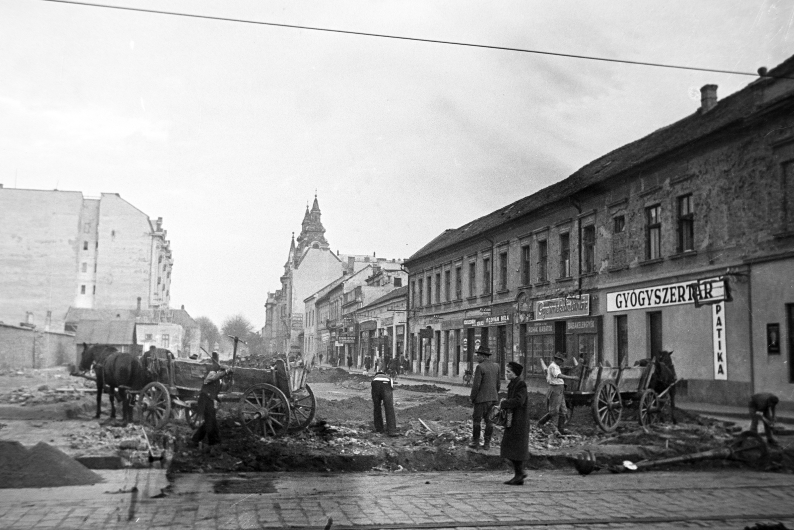 Magyarország, Debrecen, Szent Anna utca (Béke útja) a Piac utca (Vörös Hadsereg útja) felől a Szent Anna-székesegyház felé nézve., 1948, Bojár Sándor, utcakép, felirat, szekér, ló, csákány, gyógyszertár, Fortepan #195672
