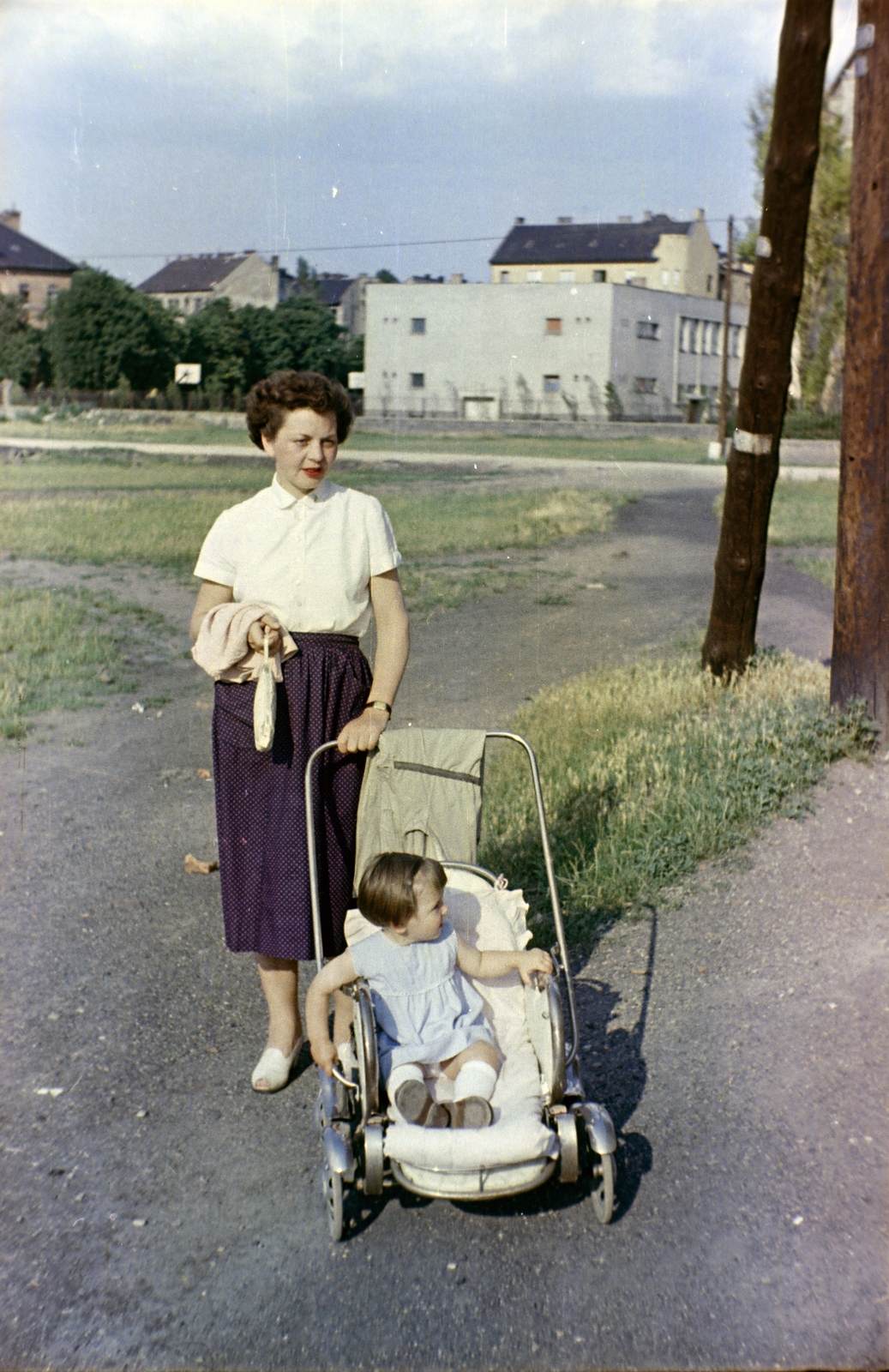 Hungary, Budapest XI., a mai Pór Bertalan köz környéke a Petzvál József utca felé nézve, háttérben középen a Fehérvári 47., a Pamuttextil Kultúrház, később Fővárosi Művelődési Ház épülete., 1954, Martin Kornél, Budapest, baby carriage, colorful, mother, Fortepan #196726