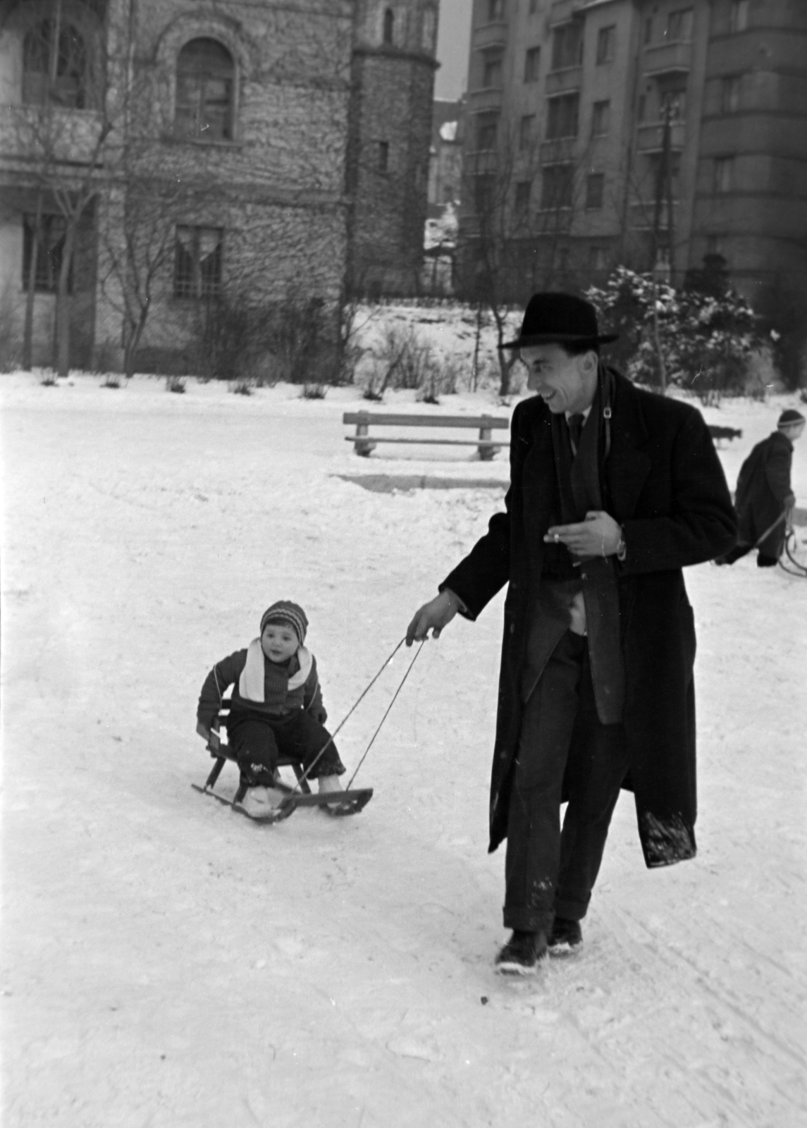 Hungary, Budapest XI., Károli Gáspár tér, játszótér, háttérben a Kelenföldi Evangélikus Egyházközösség temploma., 1954, Martin Kornél, snow, sledge, man, kid, Budapest, Fortepan #196932