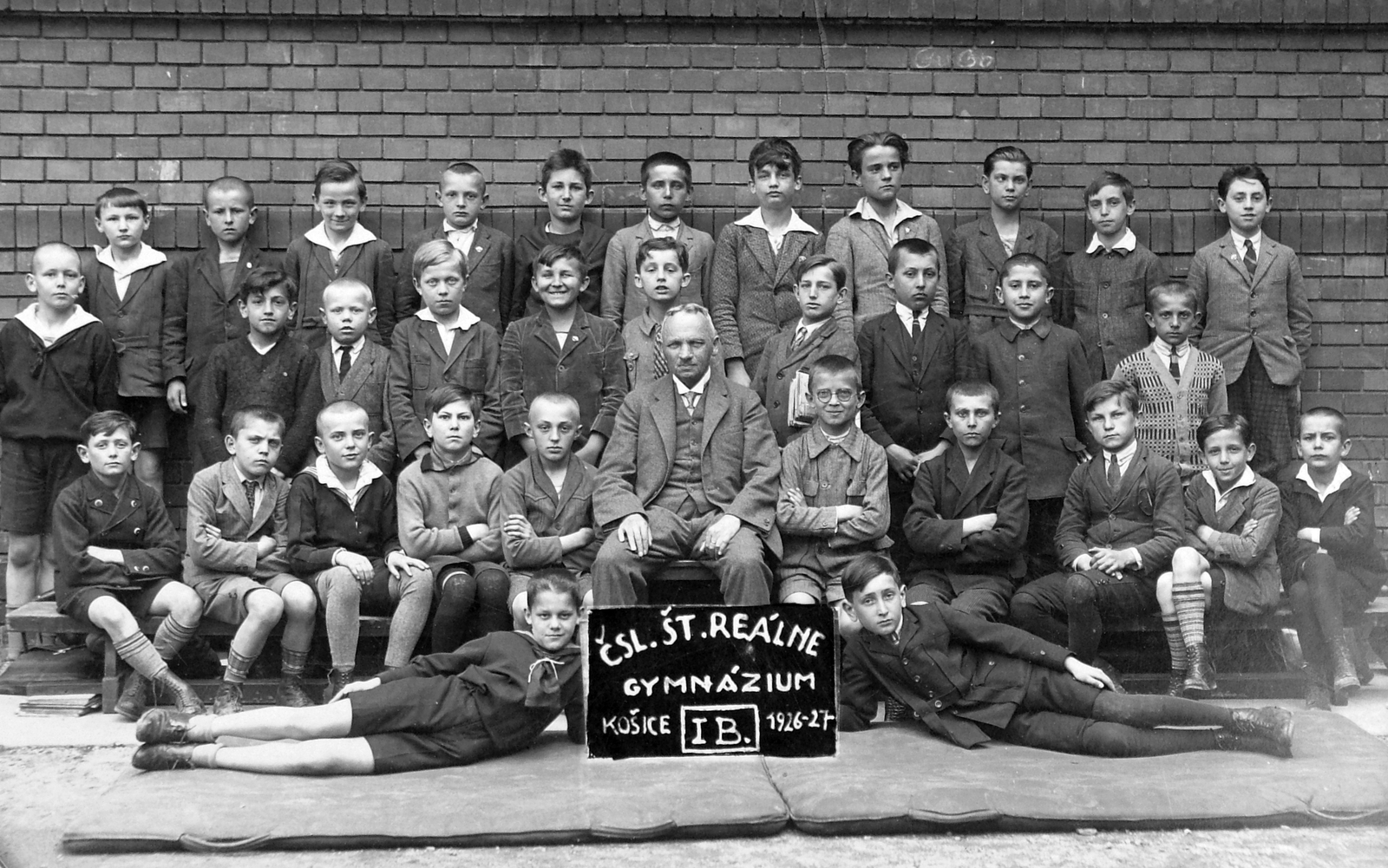 Slovakia, Košice, Kovács utca (Kováčska ulica) 28., Csehszlovák Állami Reálgimnázium, csoportkép egy elsős osztályról., 1927, Wein Sarolta, Czechoslovakia, yard, class photo, tableau, man, boys, teacher, gymnastic mat, arms crossed over the chest, sitting with hands on knees, Fortepan #19713