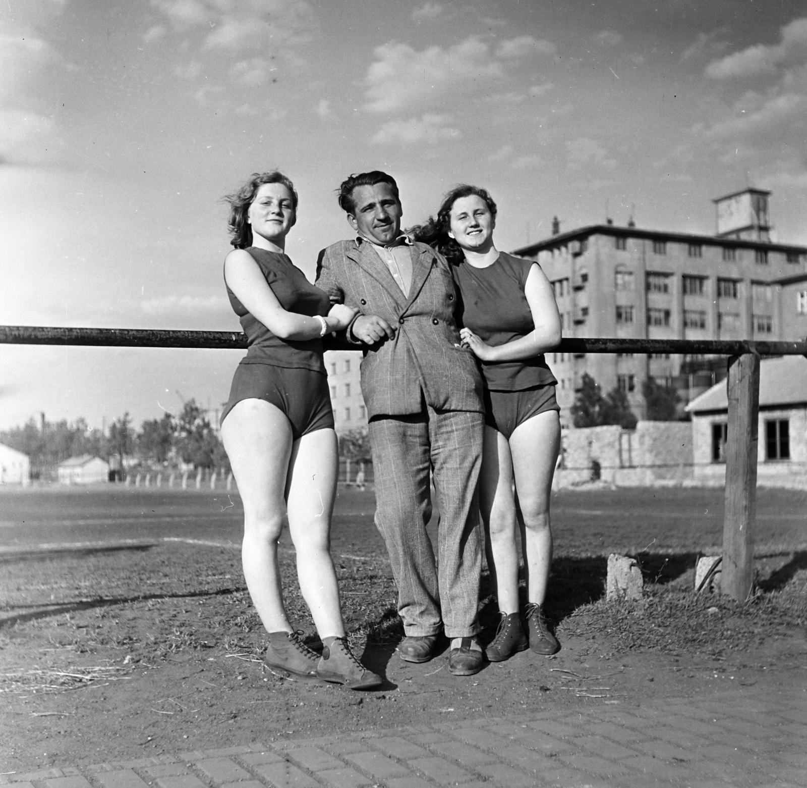 Hungary, Budapest X., Maglódi út 4. sportpálya, a Kinizsi Sörgyár női röplabdacsapat tagjai, háttérben a Növényolaj és Szappangyár., 1955, Keveházi János, Budapest, photo aspect ratio: square, woman, sportsperson, pride, Fortepan #197200