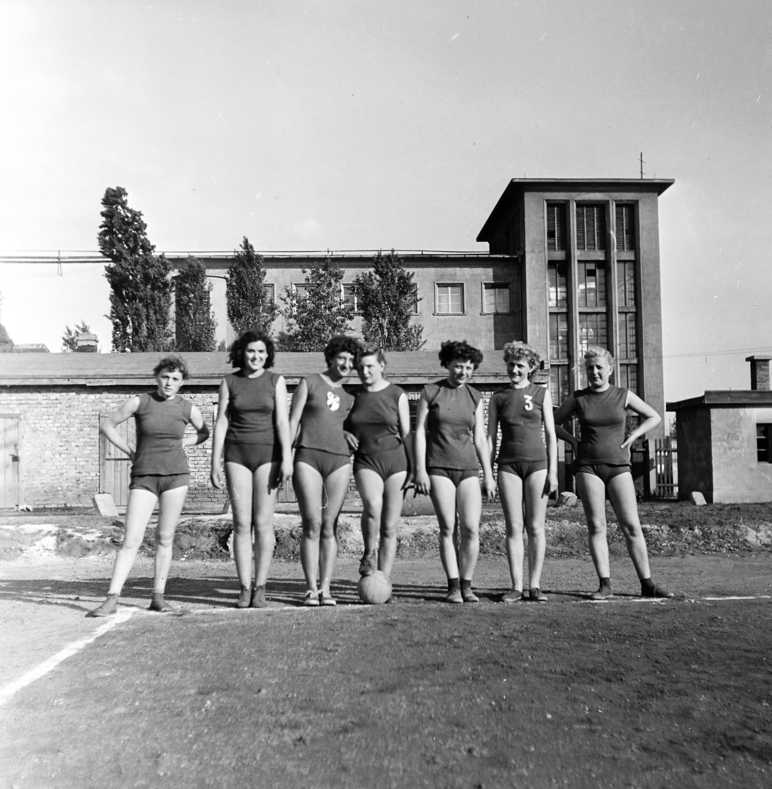 Hungary, Budapest X., Maglódi út 4. sportpálya, a Kinizsi Sörgyár női röplabdacsapat tagjai, háttérben a Növényolaj és Szappangyár., 1955, Keveházi János, Budapest, photo aspect ratio: square, woman, akimbo, volleyball, Fortepan #197202