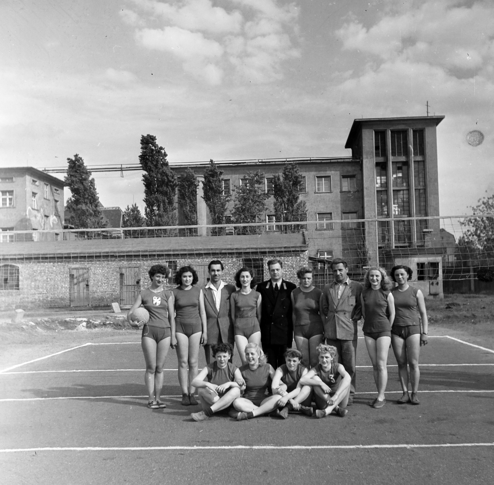 Hungary, Budapest X., Maglódi út 4. sportpálya, a Kinizsi Sörgyár női röplabdacsapat tagjai, háttérben a Növényolaj és Szappangyár., 1955, Keveházi János, Budapest, tableau, photo aspect ratio: square, volleyball, Fortepan #197205