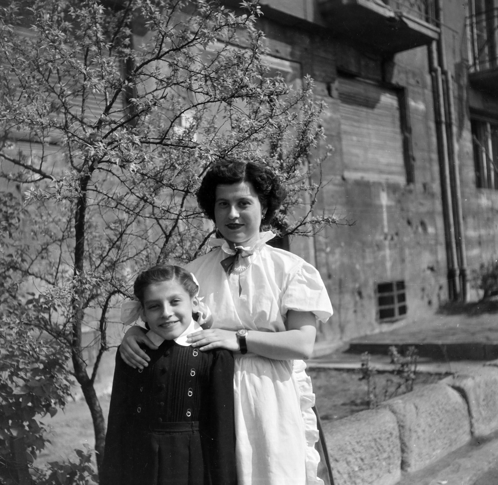 Hungary, Budapest XIV., a felvétel a Hungária körút 87. számú ház előtt készült., 1955, Keveházi János, Budapest, girl, photo aspect ratio: square, mother, smile, white dress, bullet hole, wrist watch, spring, Fortepan #197217