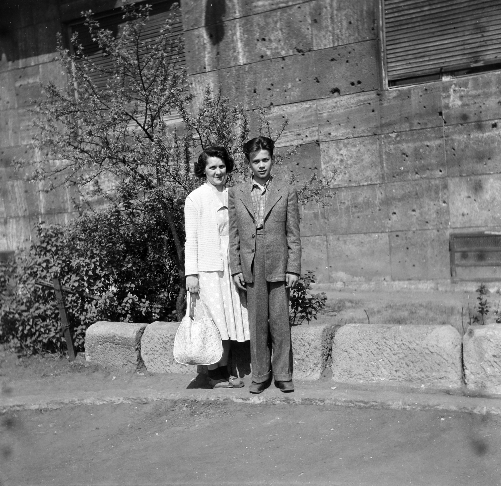 Hungary, Budapest XIV., a felvétel a Hungária körút 87. számú ház előtt készült., 1955, Keveházi János, Budapest, photo aspect ratio: square, suit, teenager, boy, double portrait, bullet hole, Fortepan #197224