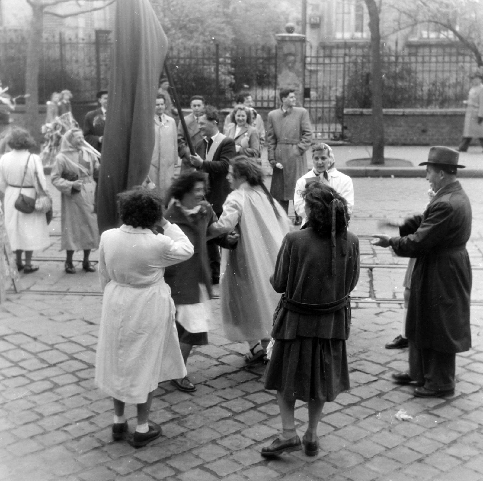 Hungary, Budapest XIV., Thököly út, május 1-i felvonulás résztvevői. Háttérben a 75-ös számú ház kerítése., 1956, Keveházi János, Budapest, photo aspect ratio: square, waiting, dance, Fortepan #197389