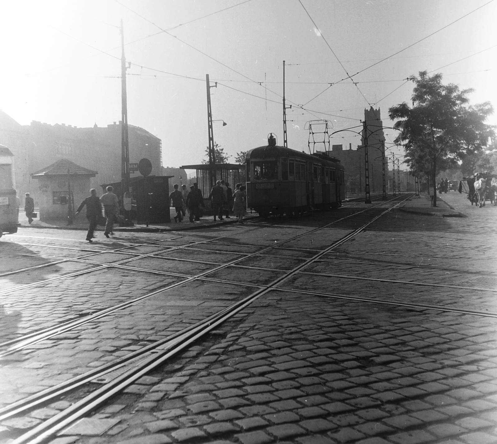 Hungary, Budapest VIII., Fiumei (Mező Imre) út a Magdolna (Koltói Anna) utca - Salgótarjáni utca közötti villamos kereszteződésnél. Háttérben balra a Dobozi utcai házsor, szemben az OTI székház., 1958, Keveházi János, Budapest, booth, photo aspect ratio: square, destination sign, pedestrian, tram, passenger, rails, Fortepan #197610