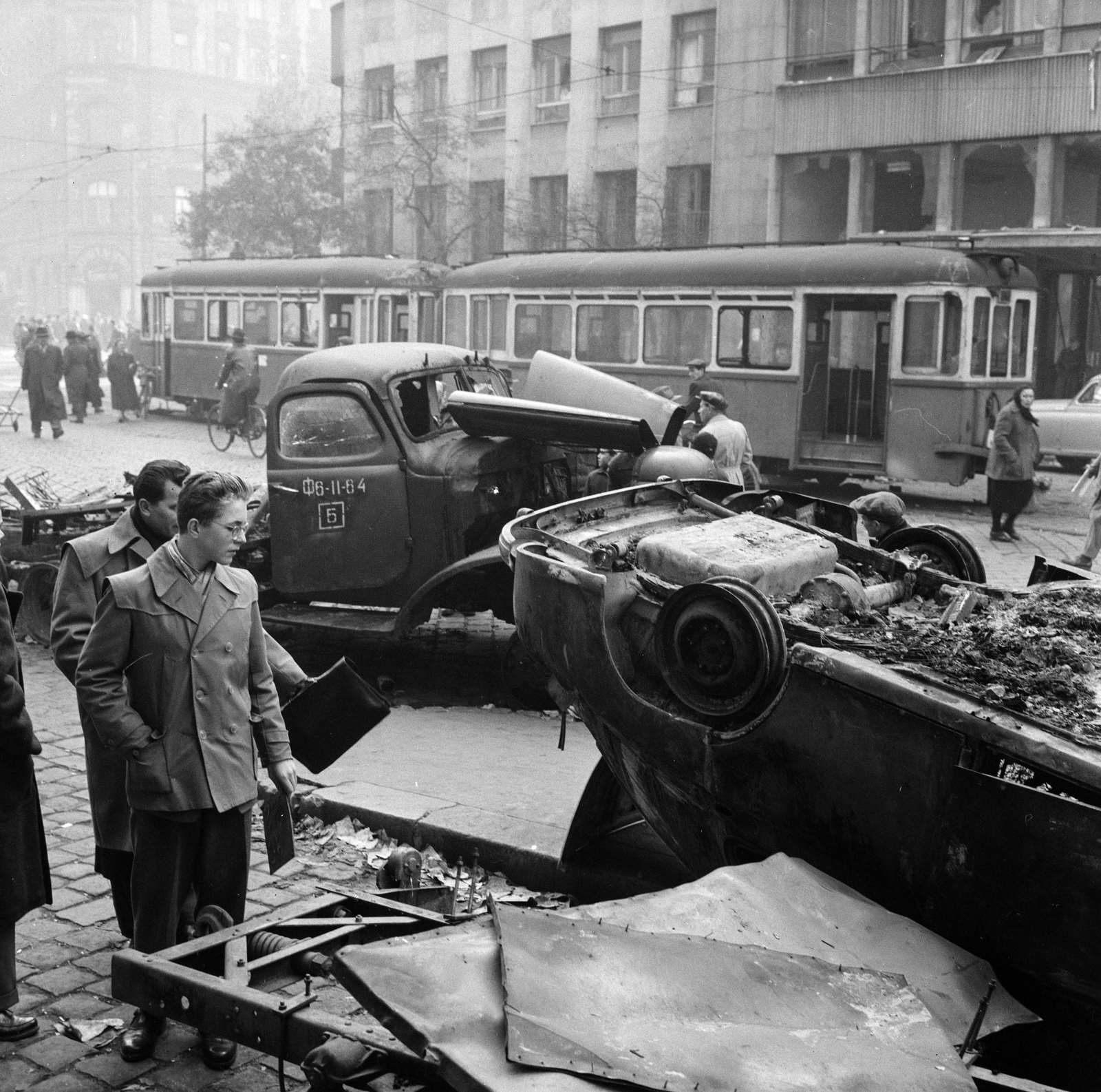 Magyarország, Budapest VIII., Blaha Lujza tér, járműroncsok a Nemzeti Színház mellett, balra a József körút, jobbra a Szabad Nép székháza., 1956, ETH Zürich, Comet Photo AG/Jack Metzger, járókelő, teherautó, utcakép, villamos, járműroncs, Budapest, képarány: négyzetes, Fortepan #197812