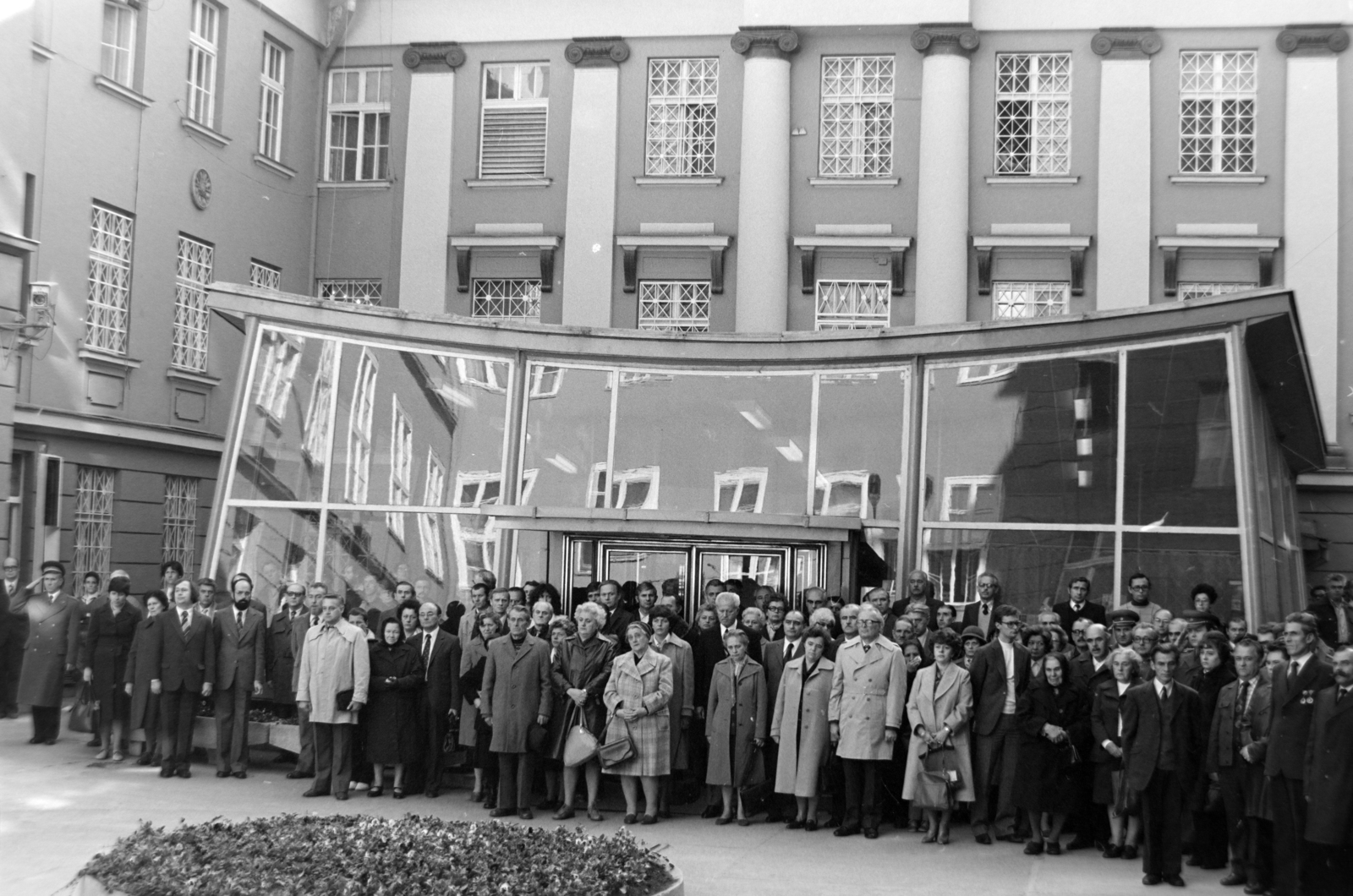 Hungary, Budapest VIII., Bródy Sándor utca 5-7., Magyar Rádió. Koszorúzás a Rádió védelmében 1956-ban elesett katonák emléktáblájánál, a 25. évforduló alkalmával. Az ünnepség résztvevői, a rádió és televízió vezetői, valamint a tömegszervezetek képviselői és az elesettek hozzátartozói az udvaron, a Pagoda előtt., 1981, Szalay Zoltán, Budapest, glass wall, Fortepan #199083