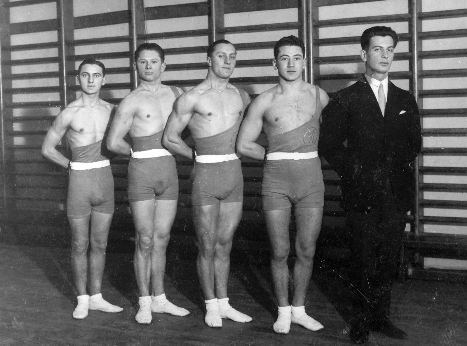 Magyarország, Budapest VIII., Szentkirályi utca 26., Nemzeti Torna Egylet tornaterme, a Budapest székesfőváros testnevelési felügyelősége levente tornászbajnoki versenyén résztvevő VII. kerületi 28. számú. leventecsapat tornászai., 1930, Fortepan, csoportkép, enteriőr, tornaterem, sportoló, bordásfal, tornaruha, izom, Budapest, hátratett kéz, kakukktojás, Fortepan #19926