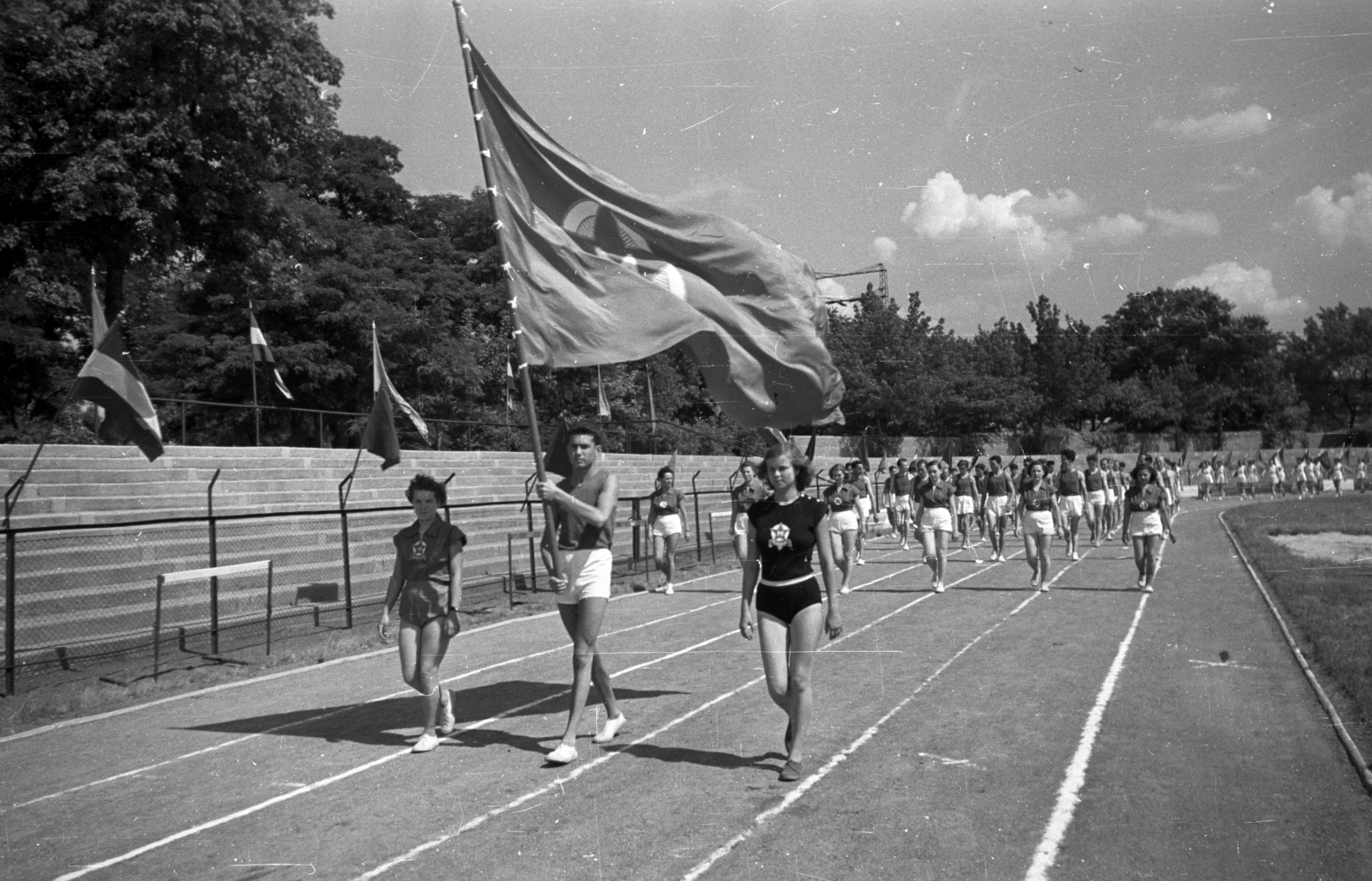 Magyarország, Népliget, Budapest X., Építők pálya., 1955, Bauer Sándor, Budapest, nők, felvonulás, zászló, sportoló, sportdressz, Fortepan #199534