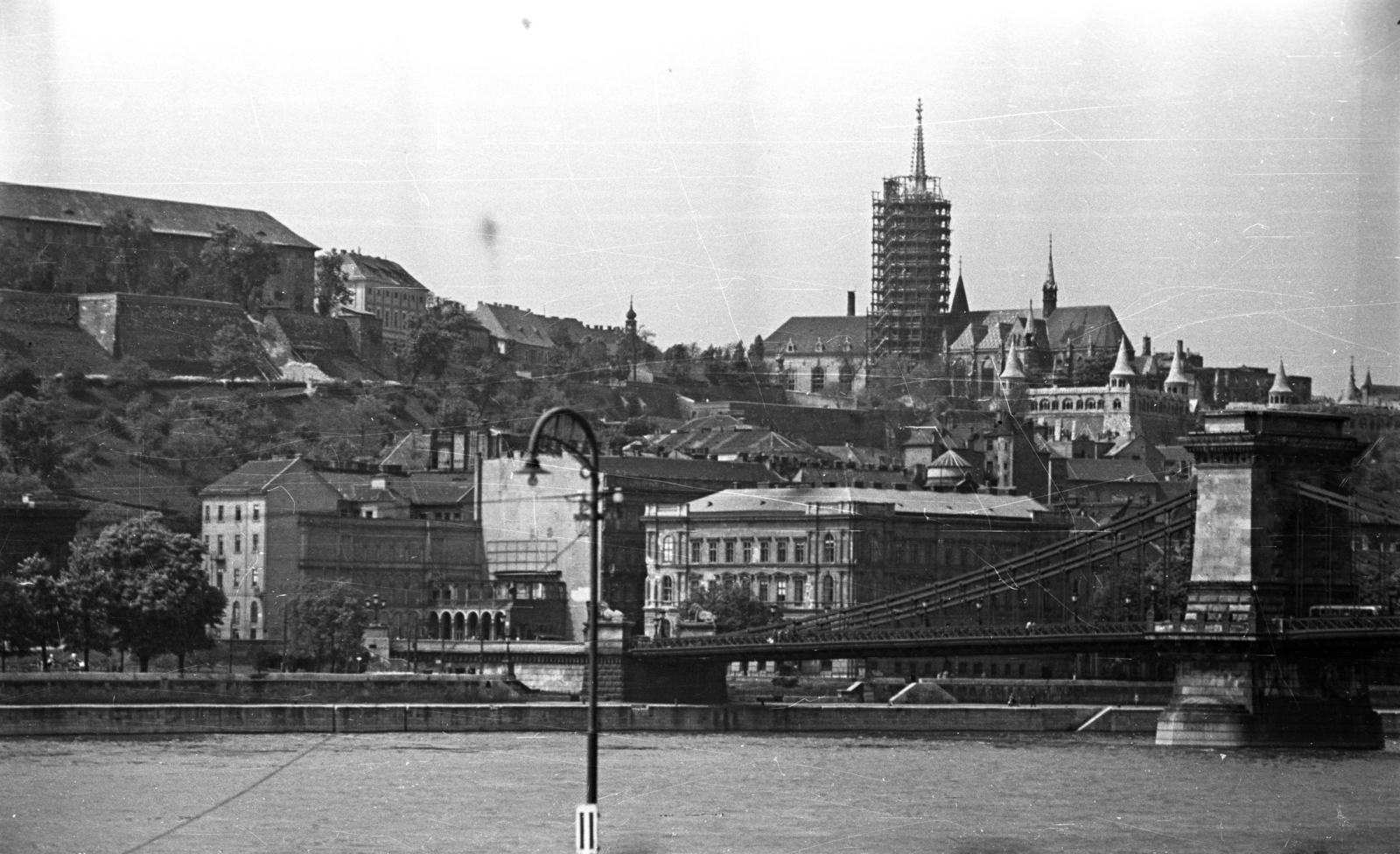 Magyarország, Budapest V.,Budapest I., kilátás a pesti alsó rakpart felől a Duna, a Széchenyi Lánchíd, a budai Vár és a felállványozott Mátyás-templom felé., 1955, Bauer Sándor, Budapest, látkép, állvány, épített örökség, helyreállítás, Fortepan #199558