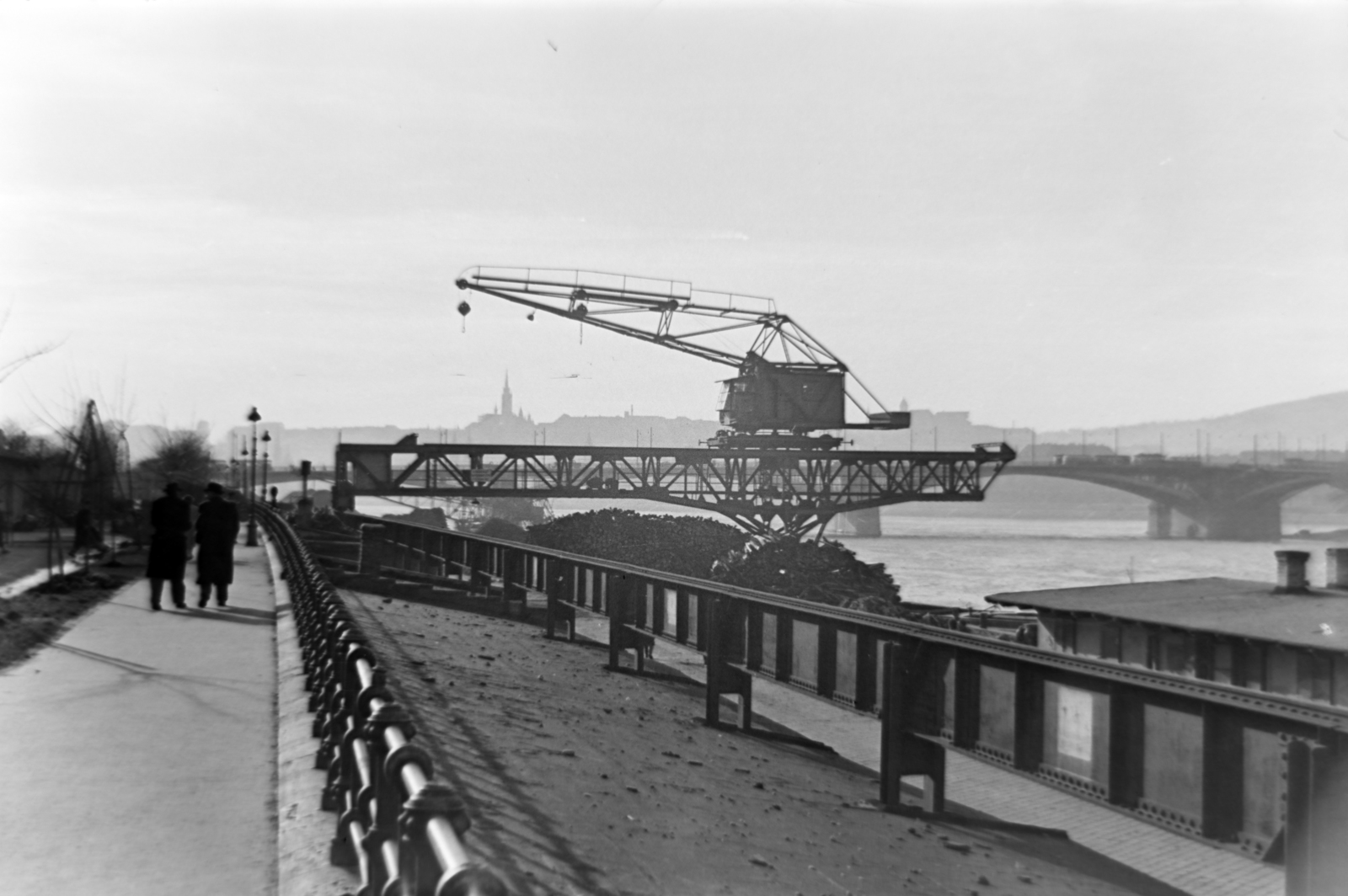 Magyarország, Budapest XIII., Újpesti rakpart, a portáldaru mögött a Margit híd és a budai Vár épületeinek sziluetje látszik., 1957, Dénes János, Duna, Budapest, Fortepan #200111