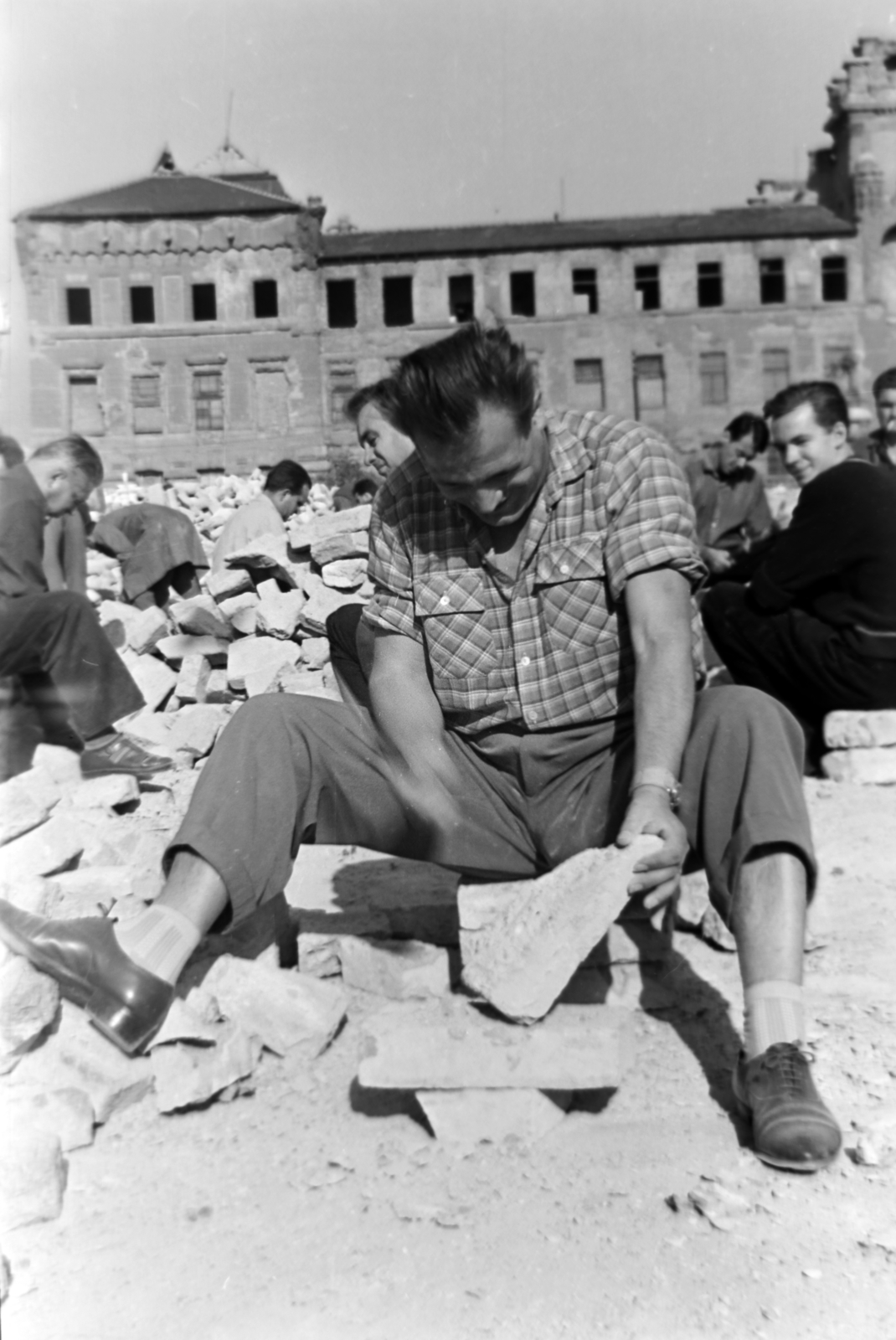 Hungary, Budapest I., a munkások a lerombolt Királyi Istálló épületeinek tégláit tisztítják a Szent György tér mellett. Szemben a romos József főhercegi palota., 1965, Dénes János, Budapest, brick, Fortepan #200256