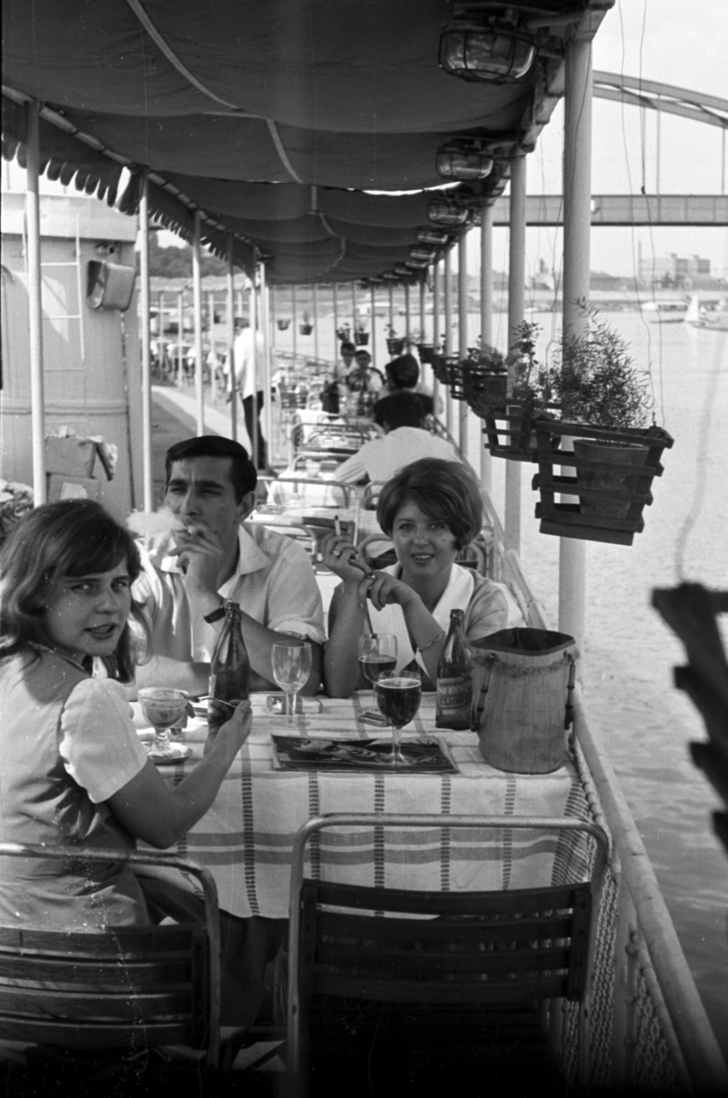 Hungary, Szeged, Tisza-part, a Szőke Tisza I. állóhajó terasza, háttérben a Belvárosi híd., 1968, Földvári Mihály, beer bottle, hospitality, looking back, smoking, Fortepan #200816