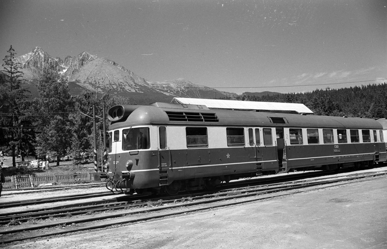 Slovakia, High Tatras, Tatranská Lomnicá, előtérben a ČSD állami vasúttársaság szerelvénye, mögötte a Tátrai Villamos Vasút (TEŽ) felsővezetéke és állomásának részlete látszik., 1972, Jakab Antal, Czechoslovakia, rails, railroad switch, catenary wire, Fortepan #202052