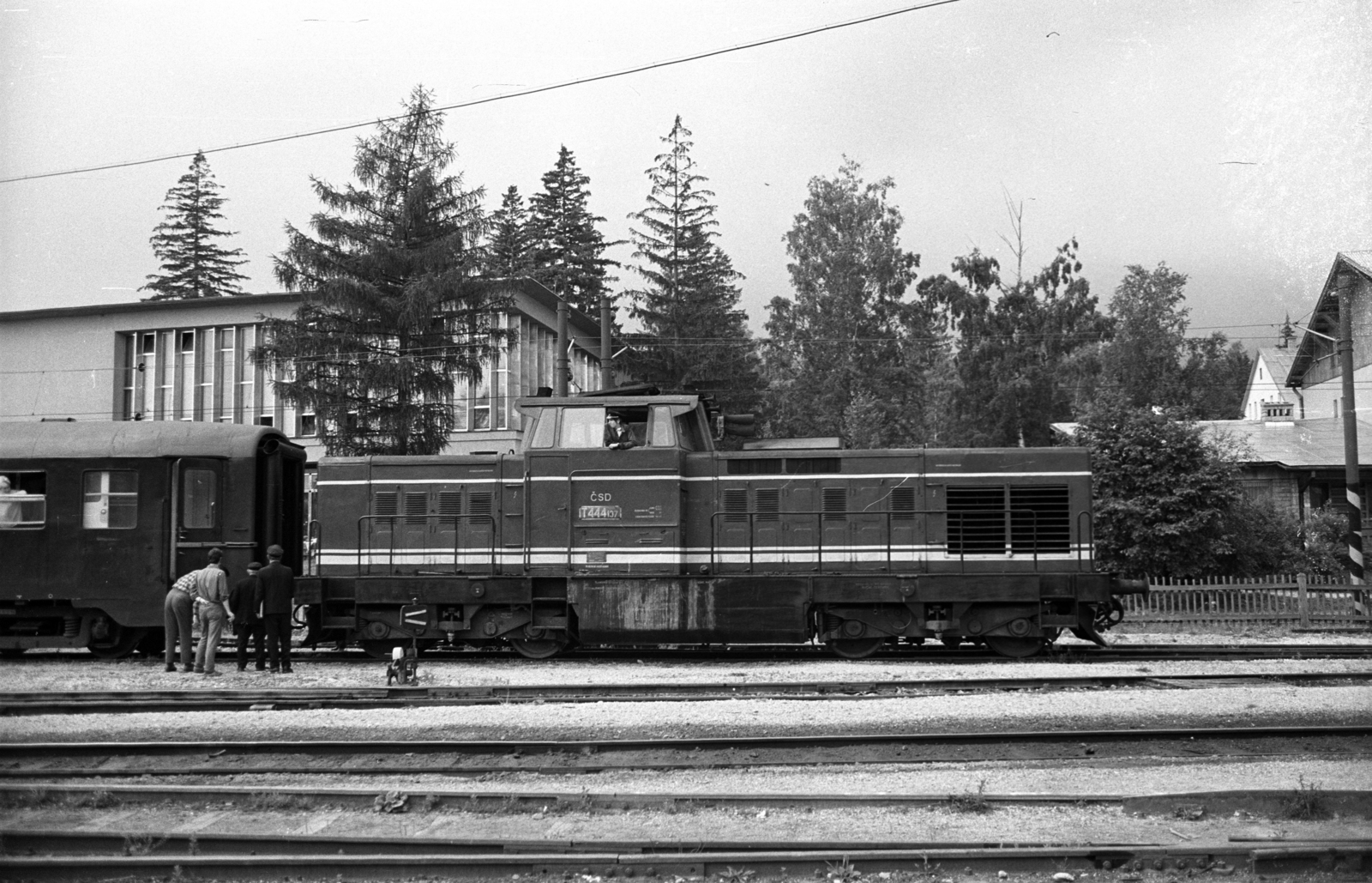 Slovakia, High Tatras, Tatranská Lomnicá, előtérben a ČSD állami vasúttársaság szerelvénye, mögötte a Tátrai Villamos Vasút (TEŽ) felsővezetéke látszik., 1972, Jakab Antal, Czechoslovakia, rail, train station, rails, diesel locomotive, railroad switch, light-signalling device, catenary wire, Fortepan #202060