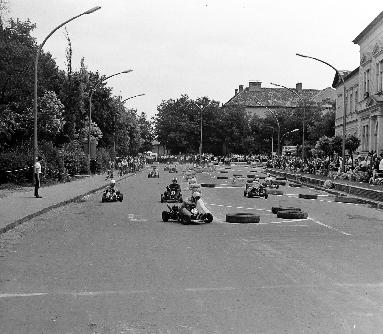 Hungary, Jászberény, Szentháromság tér, gokartverseny, jobbra a Lehel Vezér Általános Gimnázium épülete. Szemben a Lehel vezér téren a Járásbíróság épülete., 1978, Faragó László, car race, straw bale, Fortepan #202394