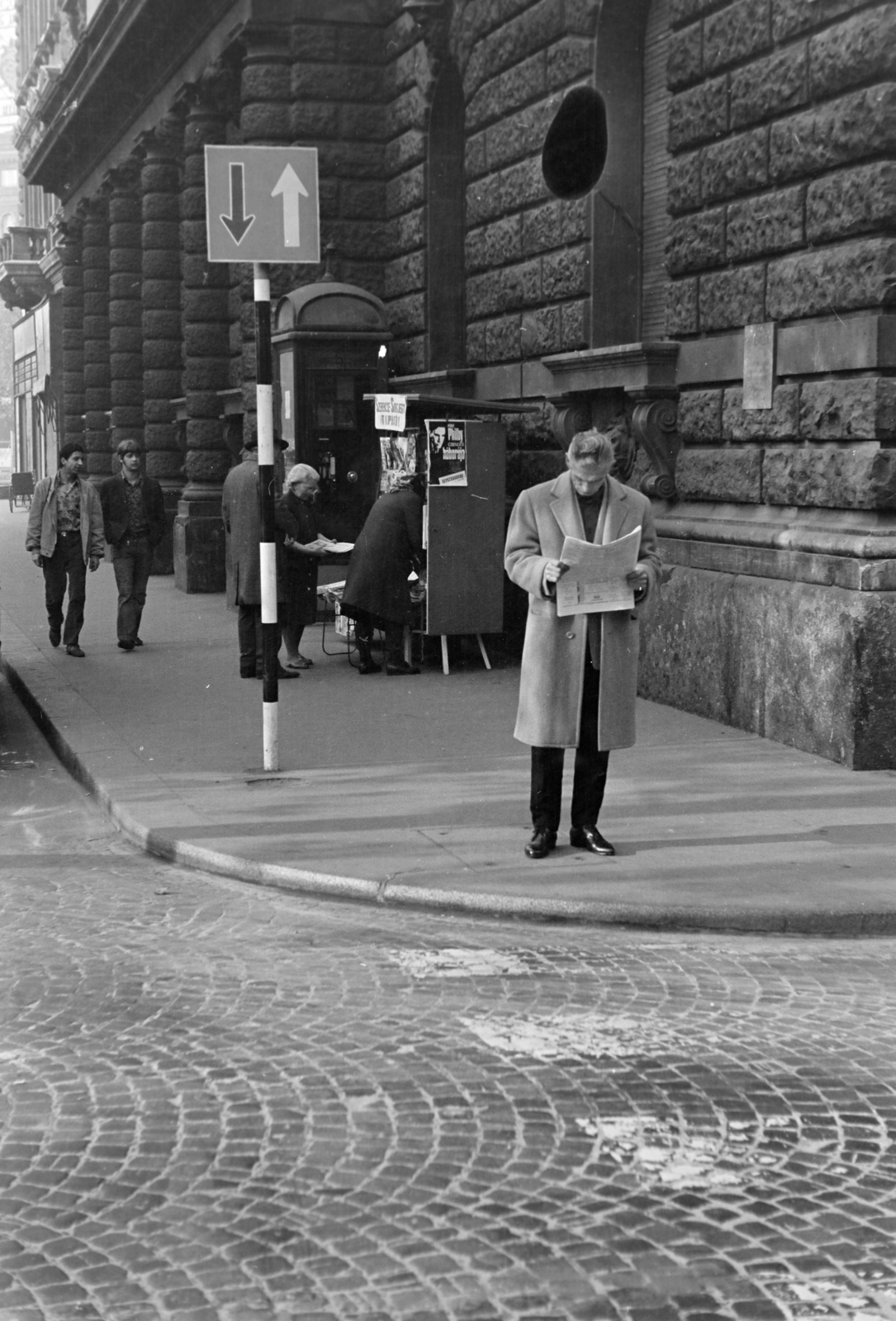 Magyarország, Budapest VI., az Andrássy út (Népköztársaság útja) és az Eötvös utca sarok az Oktogon (November 7. tér) felé nézve., 1970, Kereki Sándor, Budapest, Best of, olvasás, telefonfülke, férfi, újság, kockakő, újságárus, Fortepan #204896