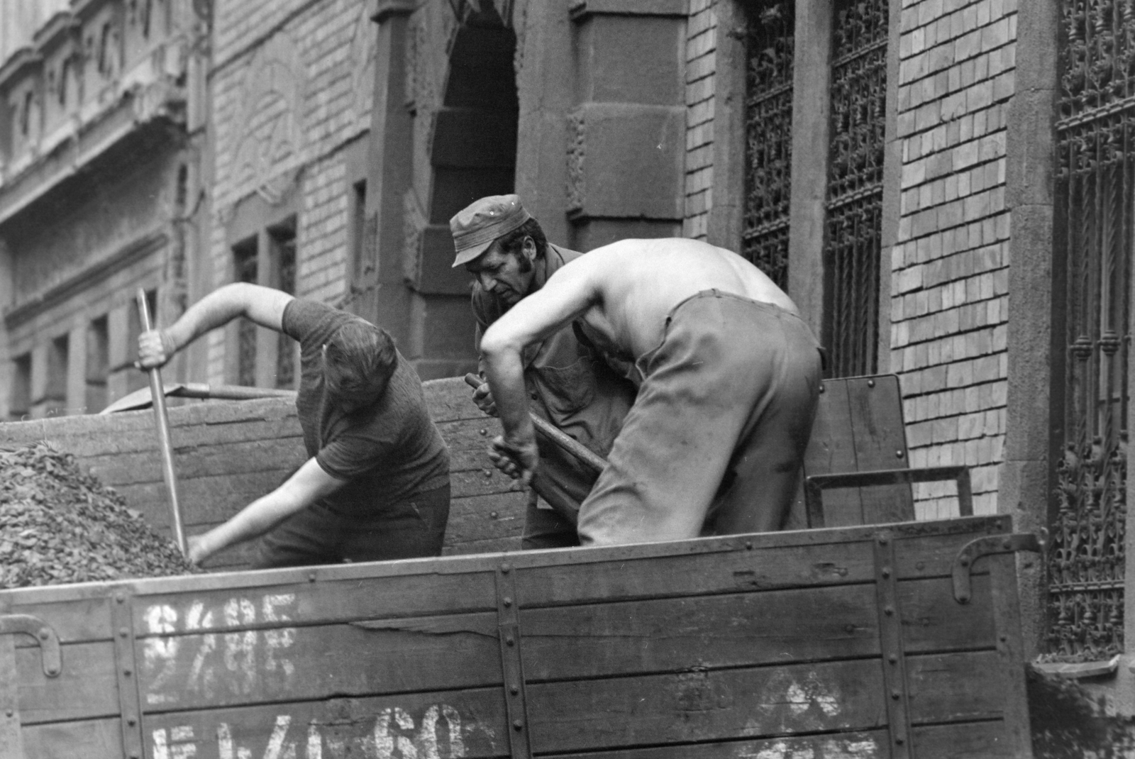 Hungary, Budapest VIII., Berzsenyi utca, szenesemberek kokszot lapátolnak a teherautóról a 6-os számú épület előtt., 1975, Kereki Sándor, Budapest, coalman, coke, Fortepan #205104