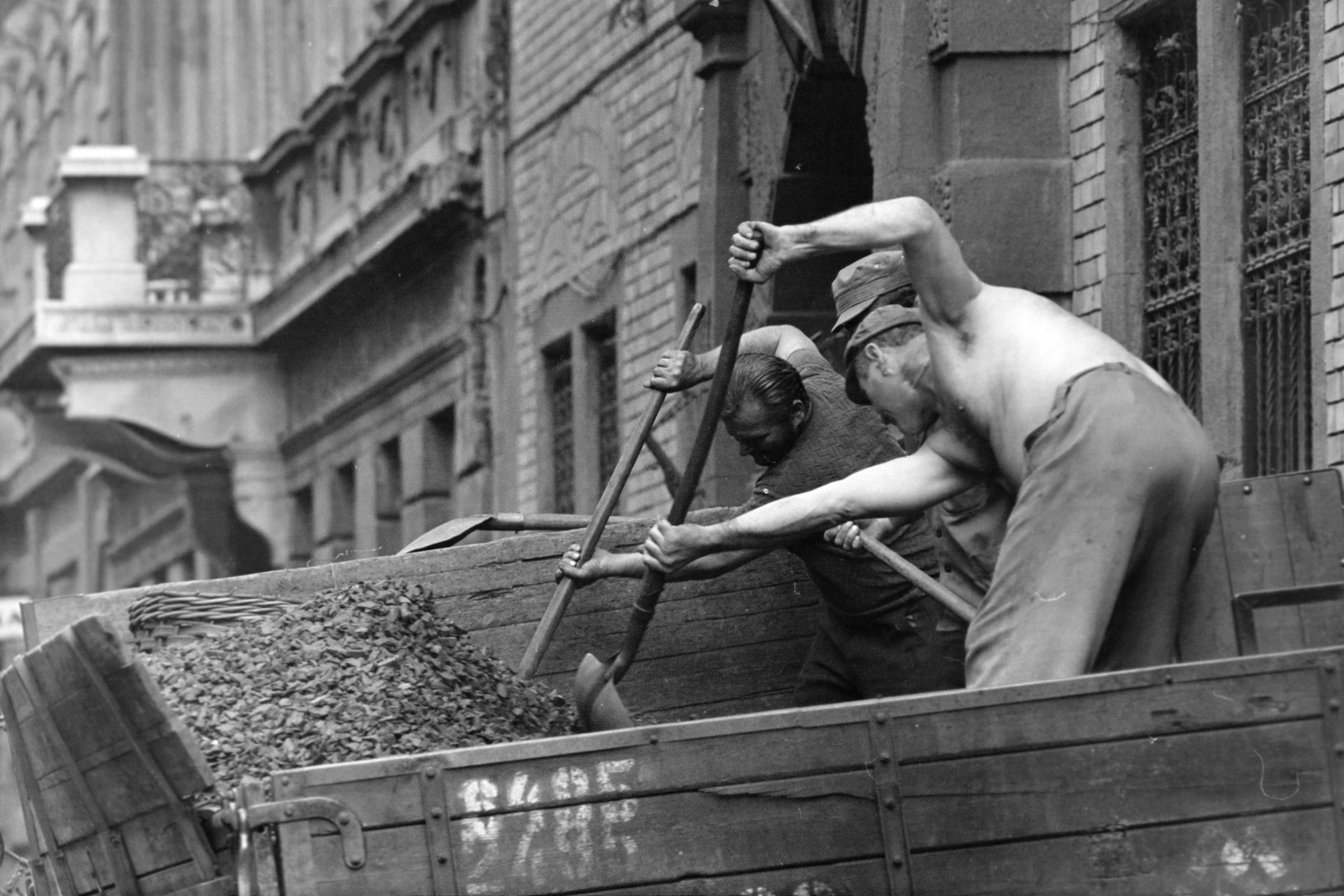 Magyarország, Budapest VIII., Berzsenyi utca, szenesemberek kokszot lapátolnak a teherautóról a 6-os számú épület előtt., 1975, Kereki Sándor, Budapest, szenesember, koksz, Fortepan #205106